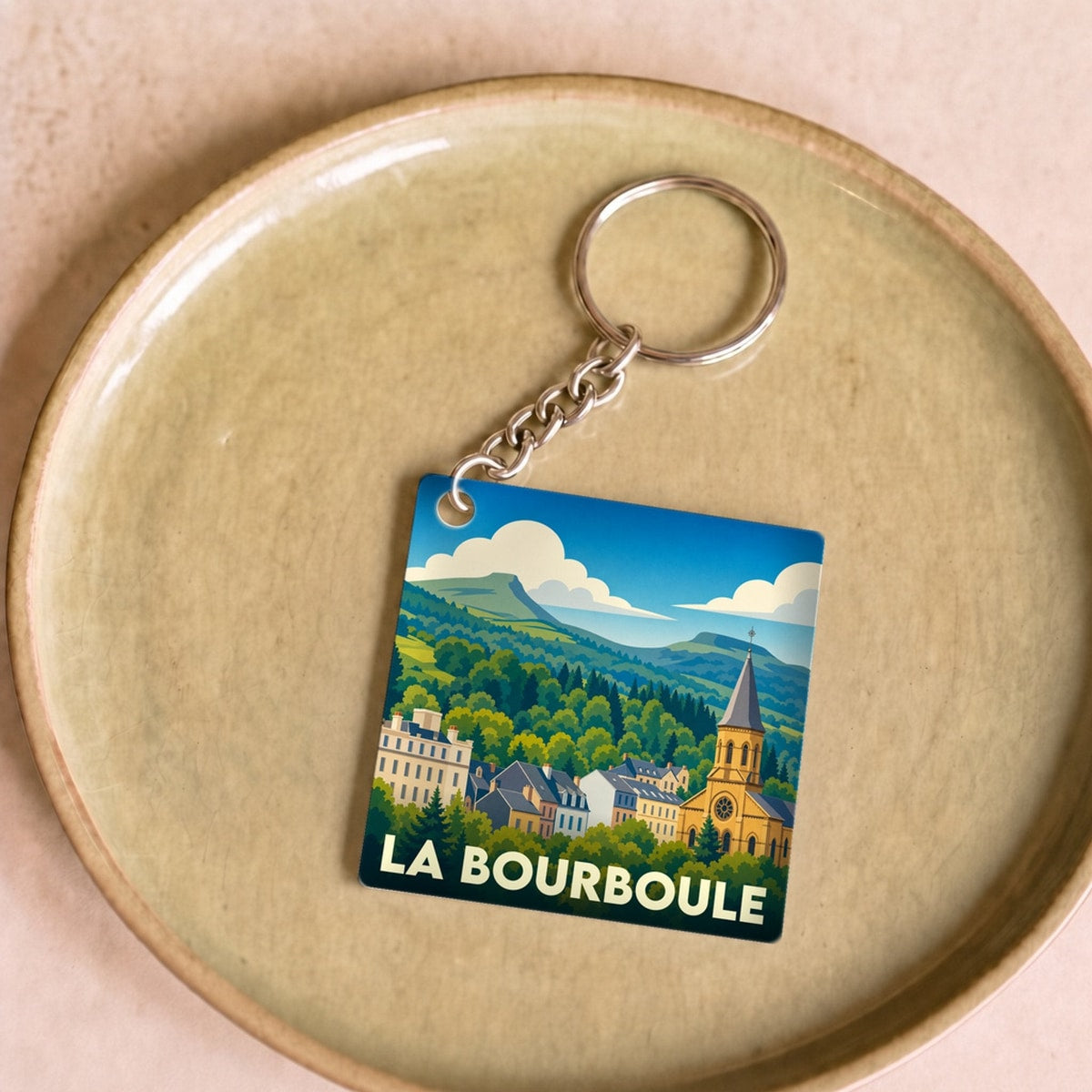 Porte-clés souvenir de la ville de La Bourboule avec une illustration stylisée.