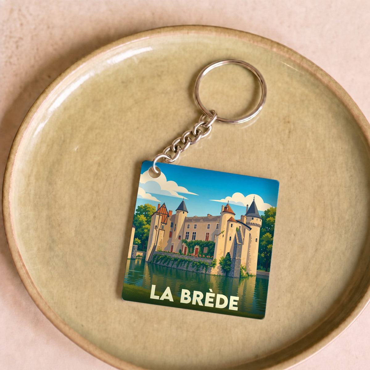 Porte-clés souvenir de la ville de La Brède avec une illustration stylisée de son château.