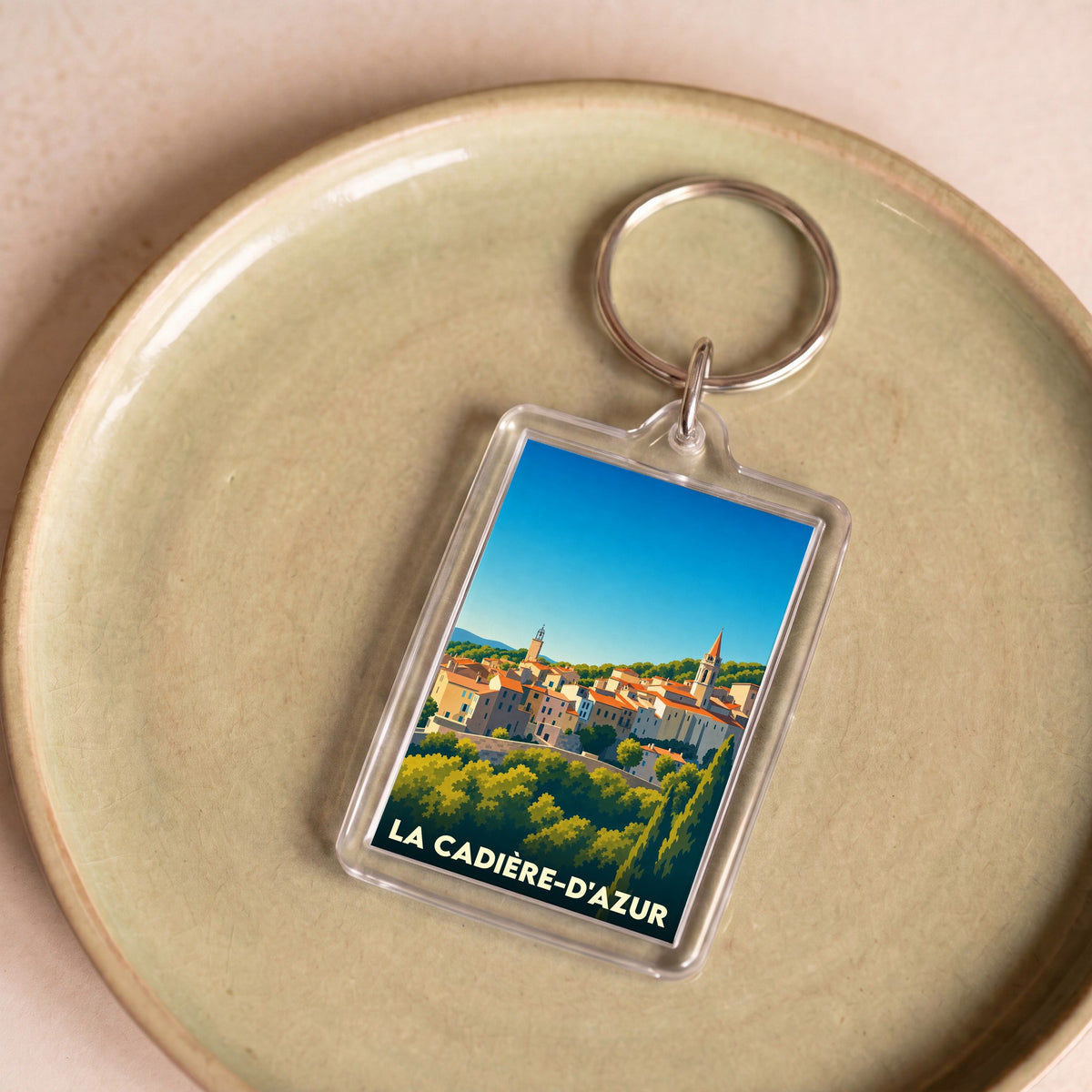 Porte-clés souvenir de la ville de La Cadière-d'Azur avec une illustration stylisée.