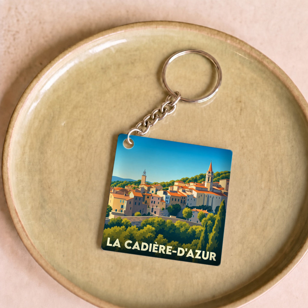 Porte-clés souvenir de la ville de La Cadière-d'Azur avec une illustration stylisée.
