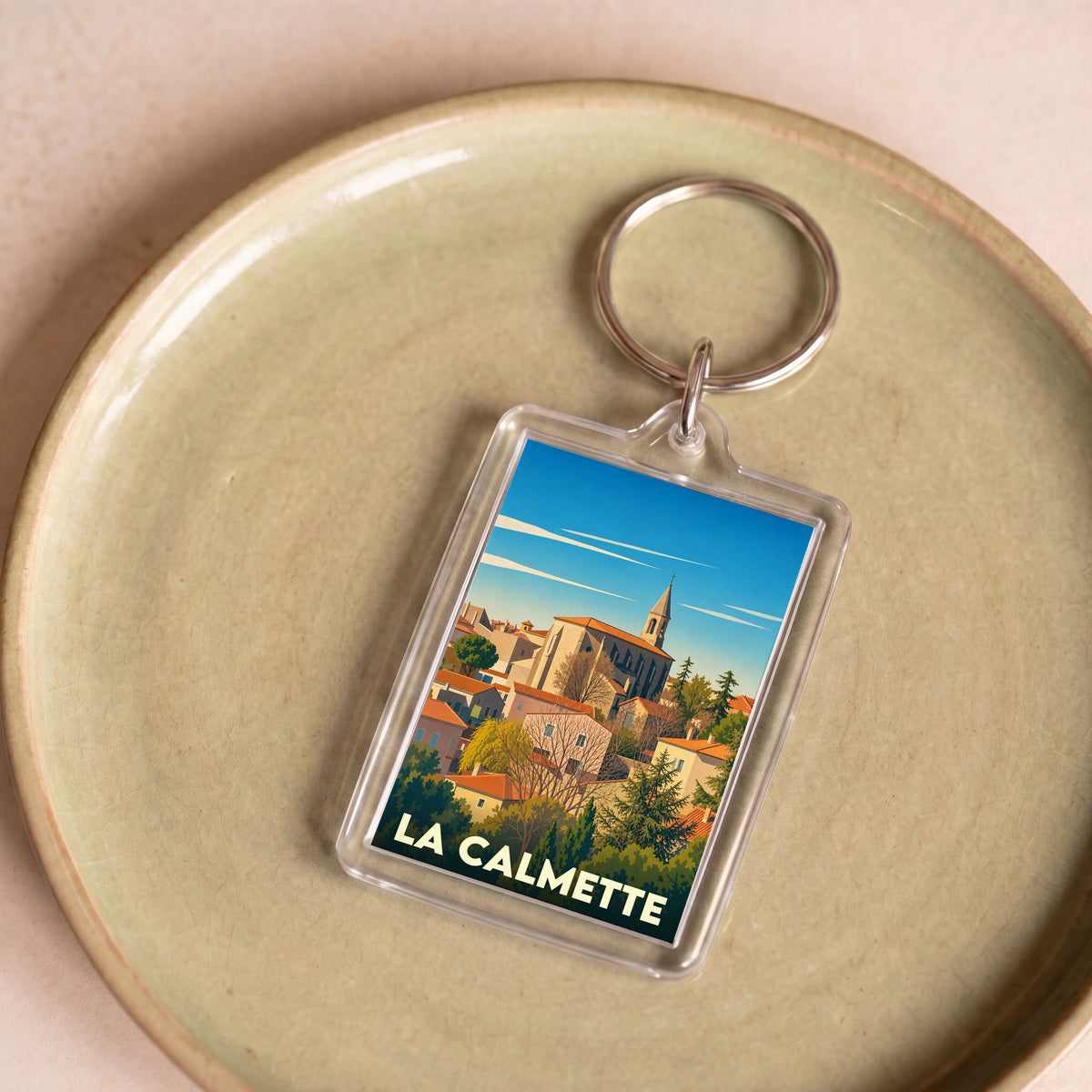 Porte-clés souvenir de la ville de La Calmette avec une illustration stylisée.