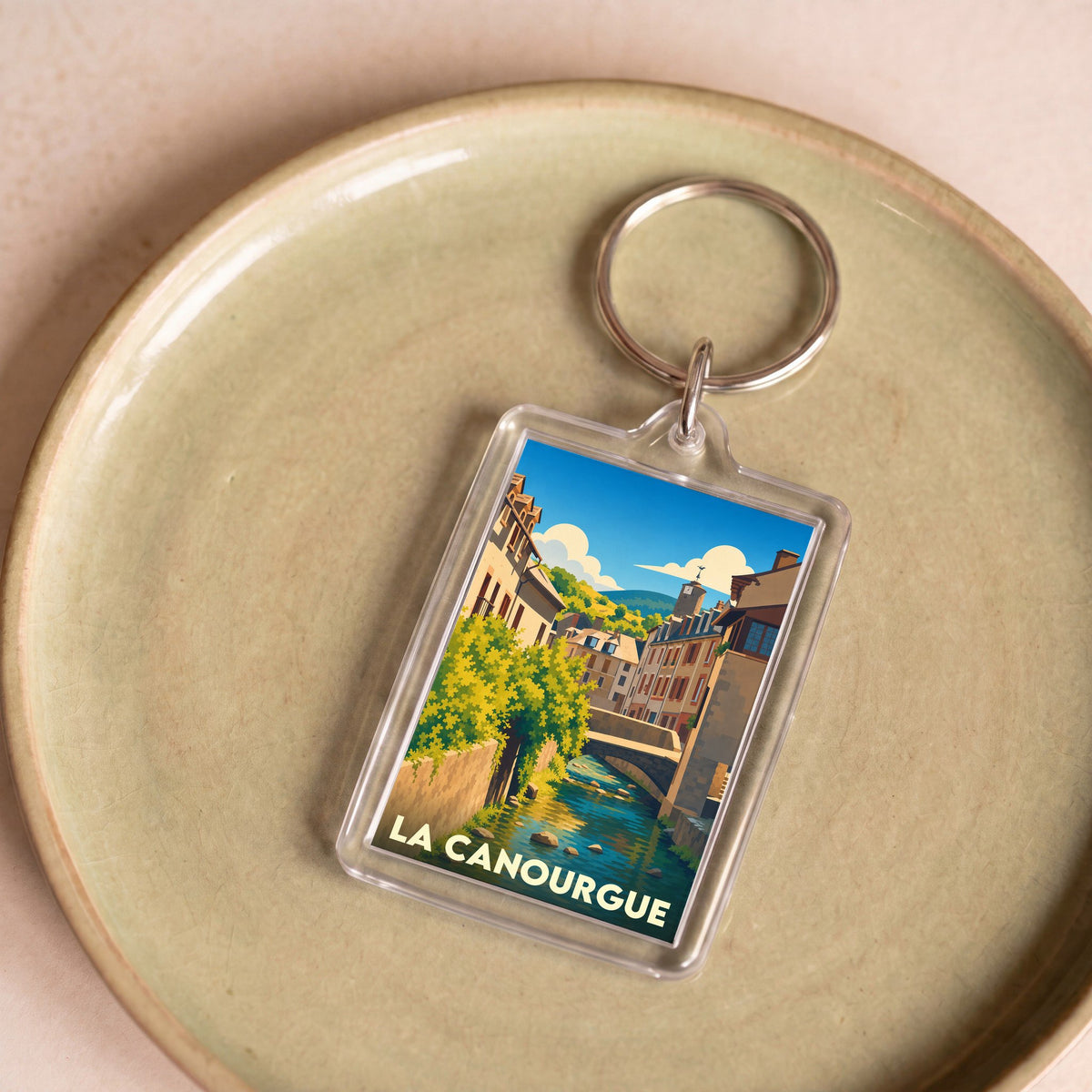 Porte-clés souvenir de la ville de La Canourgue avec une illustration stylisée.