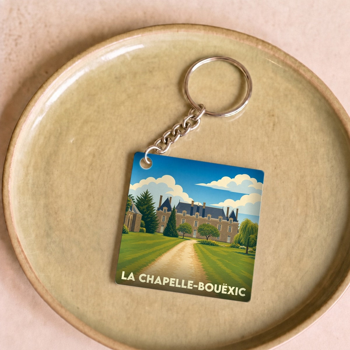 Porte-clés souvenir de la ville de La Chapelle-Bouëxic avec une illustration stylisée de son château.