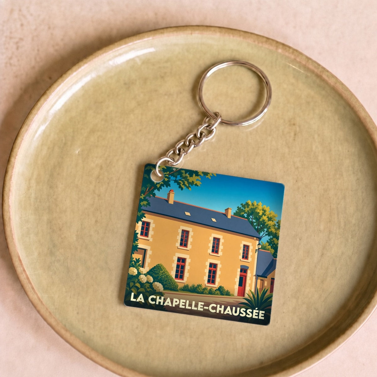 Porte-clés souvenir de la ville de La Chapelle-Chaussée avec une illustration stylisée.