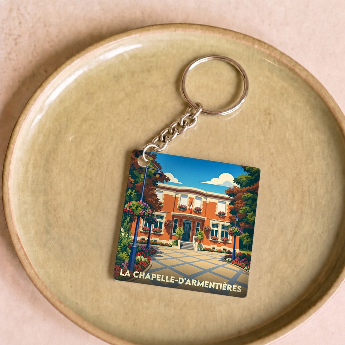 Porte-clés souvenir de la ville de La Chapelle-d'Armentières avec une illustration stylisée de l'hôtel de ville.