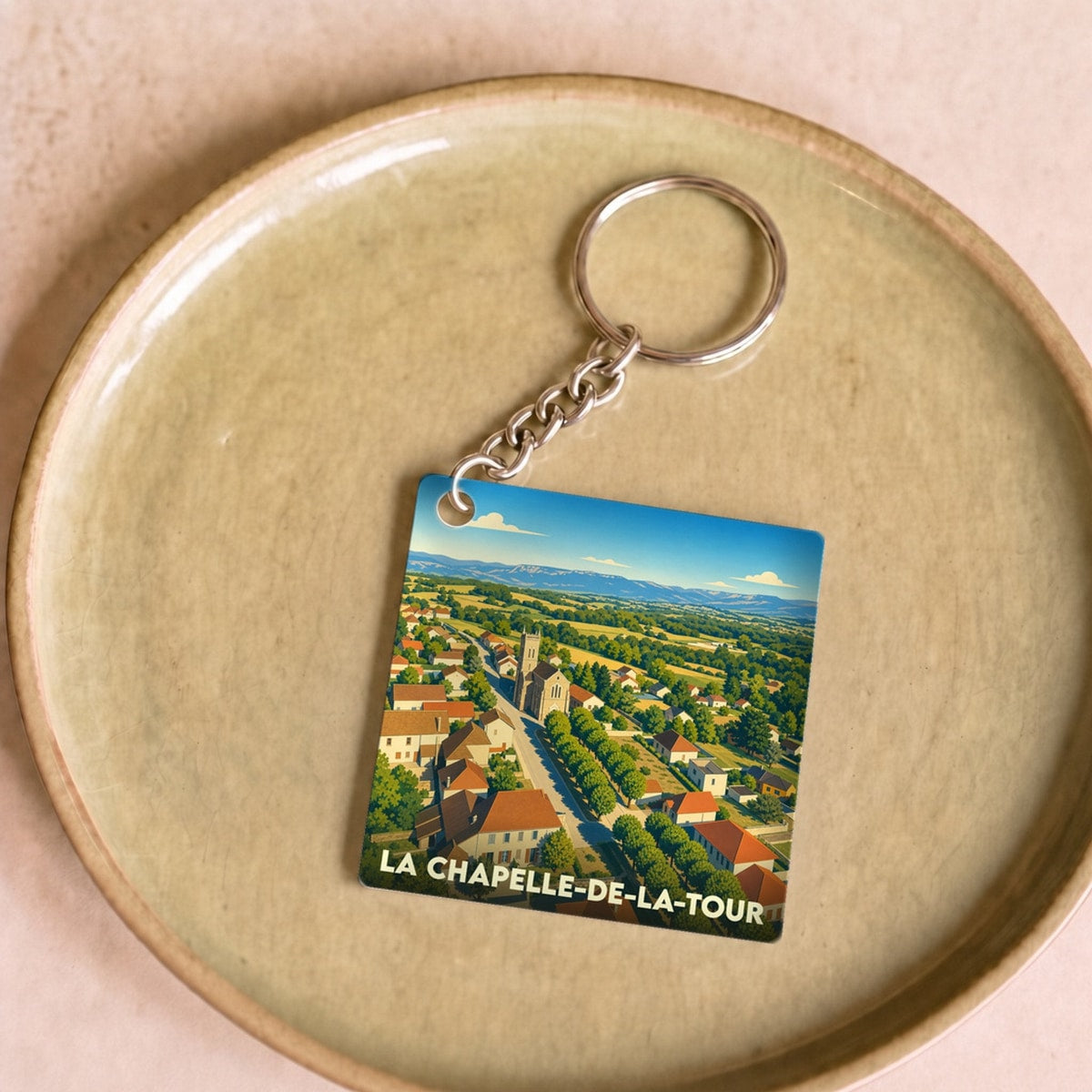 Porte-clés souvenir de la ville de La Chapelle-de-la-Tour avec une illustration stylisée.