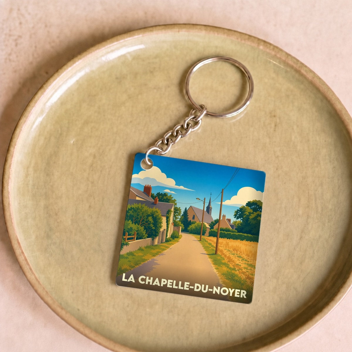 Porte-clés souvenir de la ville de La Chapelle-du-Noyer avec une illustration stylisée.