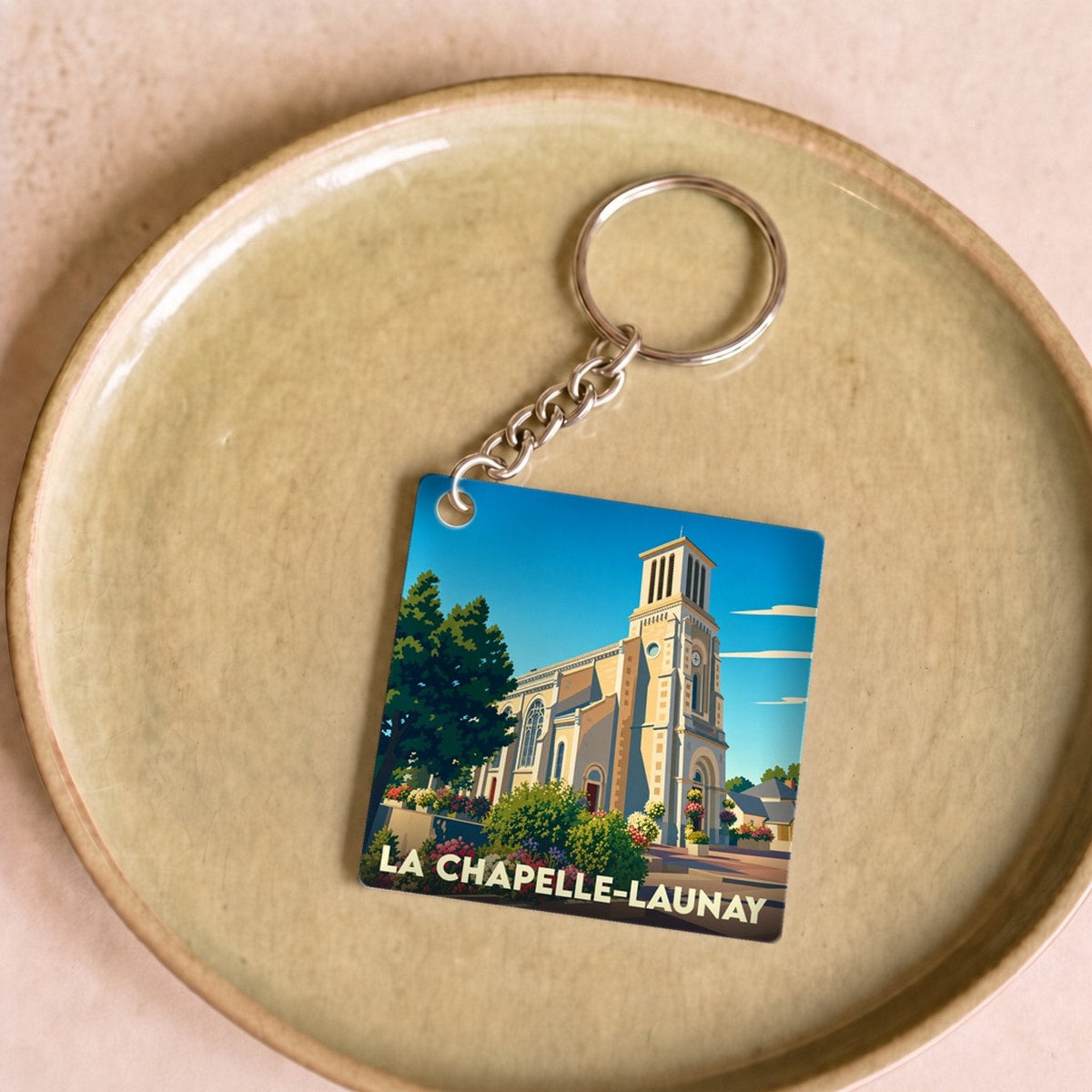 Porte-clés souvenir de la ville de La Chapelle-Launay avec une illustration stylisée de son église.