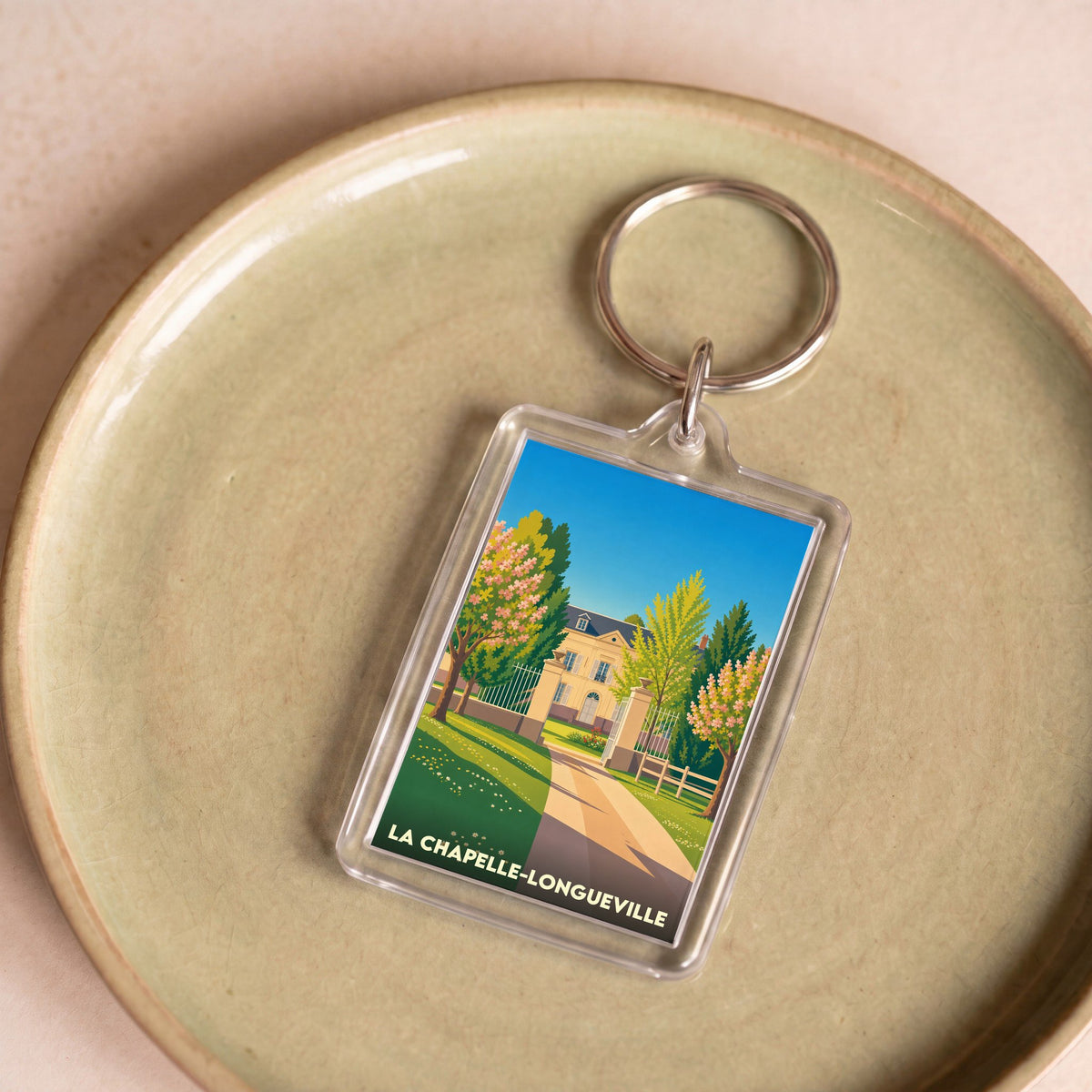 Porte-clés souvenir de la ville de La Chapelle-Longueville avec une illustration stylisée.