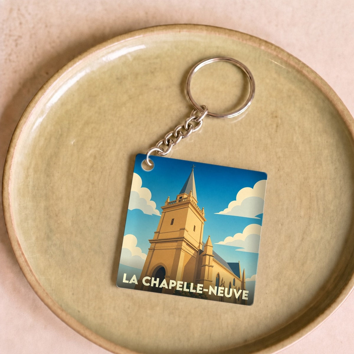 Porte-clés souvenir de la ville de La Chapelle-Neuve avec une illustration stylisée de son église.
