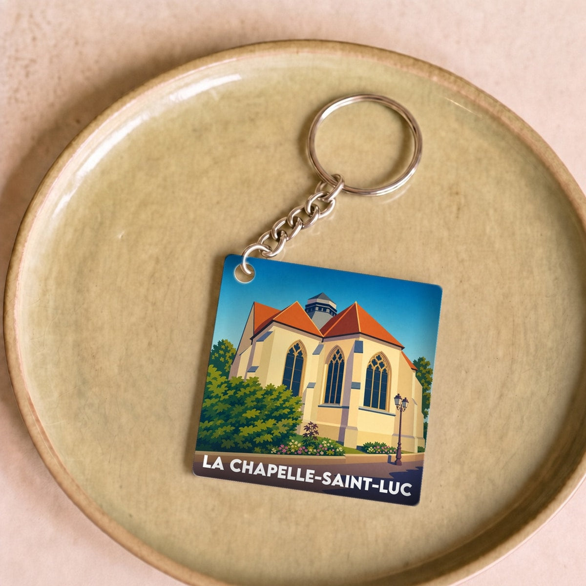 Porte-clés souvenir de la ville de La Chapelle-Saint-Luc avec une illustration stylisée.