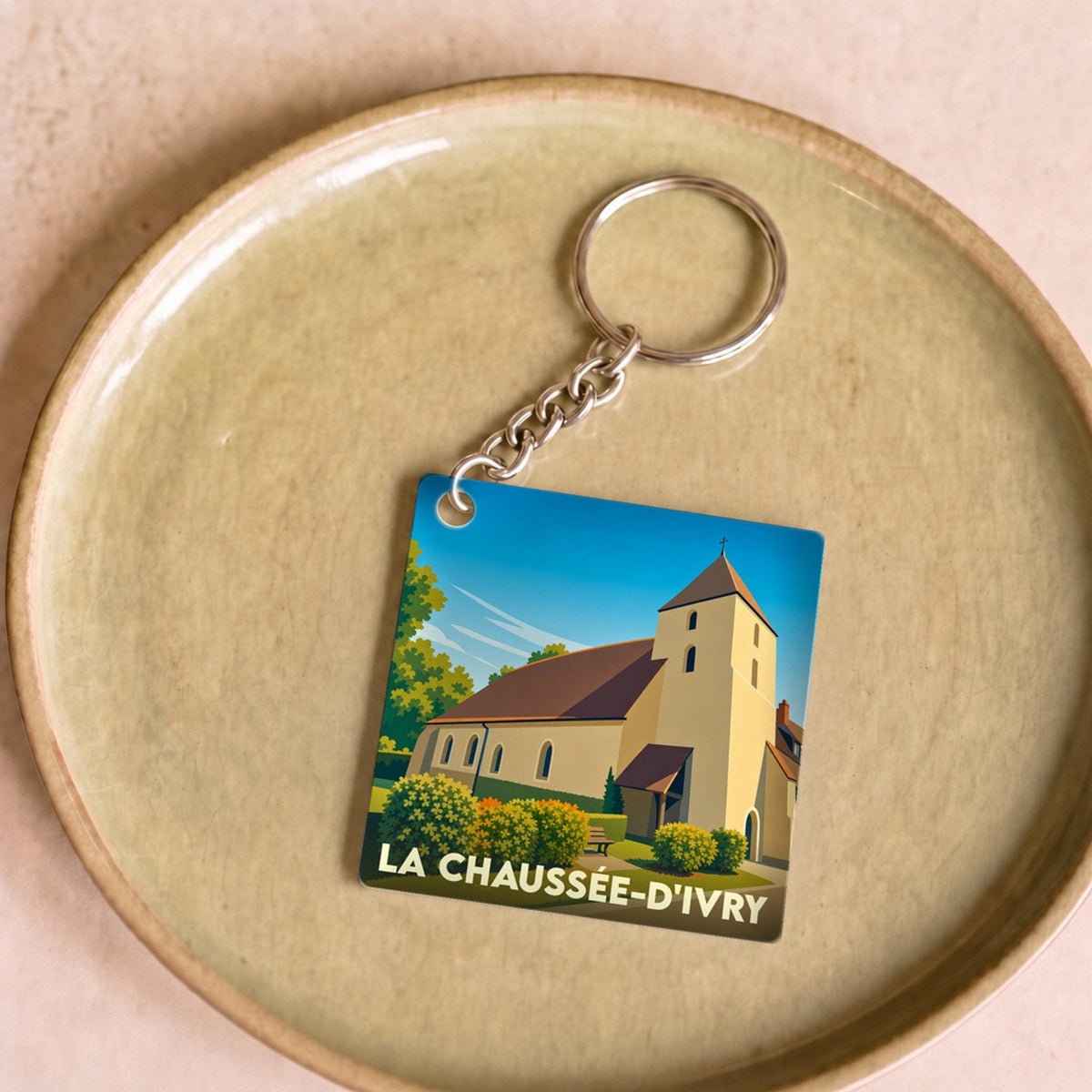 Porte-clés souvenir de la ville de La Chaussée-d'Ivry avec une illustration stylisée de son église.