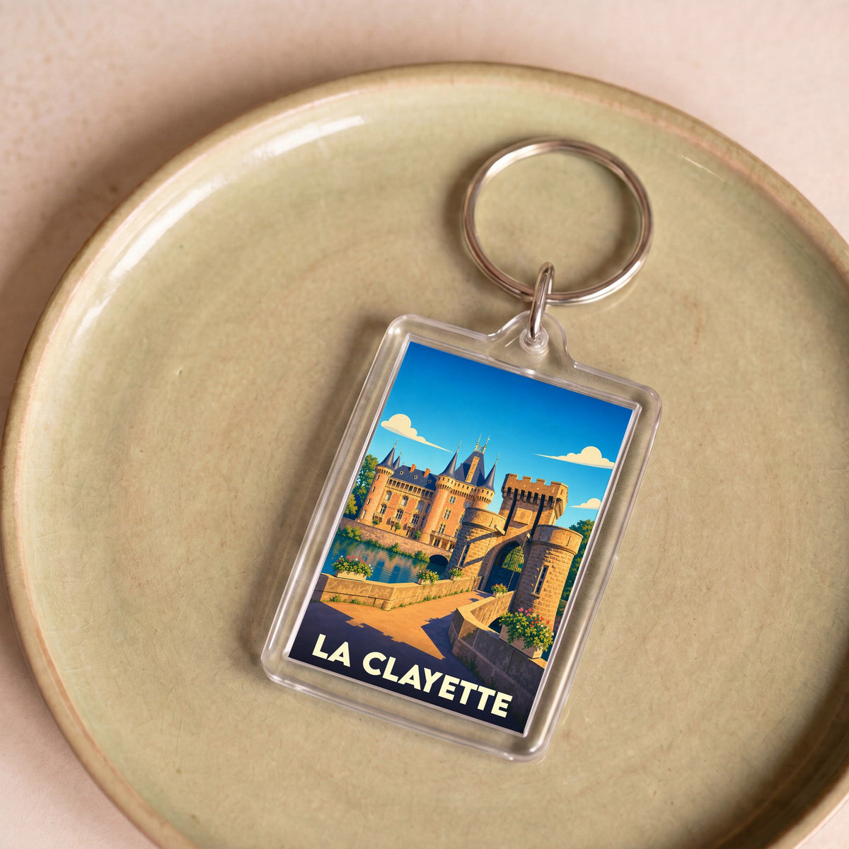 Porte-clés souvenir de la ville de La Clayette avec une illustration stylisée de son château.