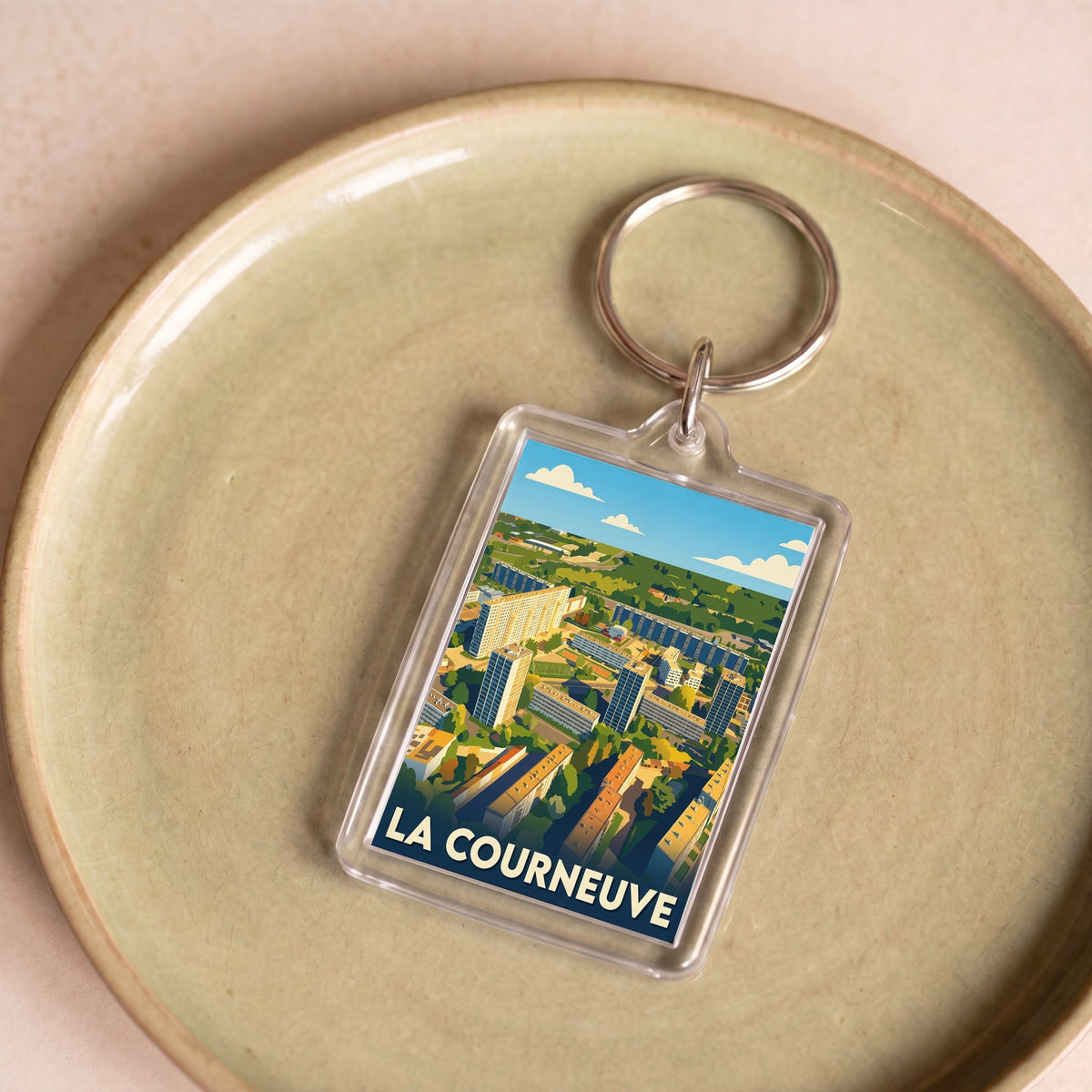 Porte-clés souvenir de la ville de La Courneuve avec une illustration stylisée.