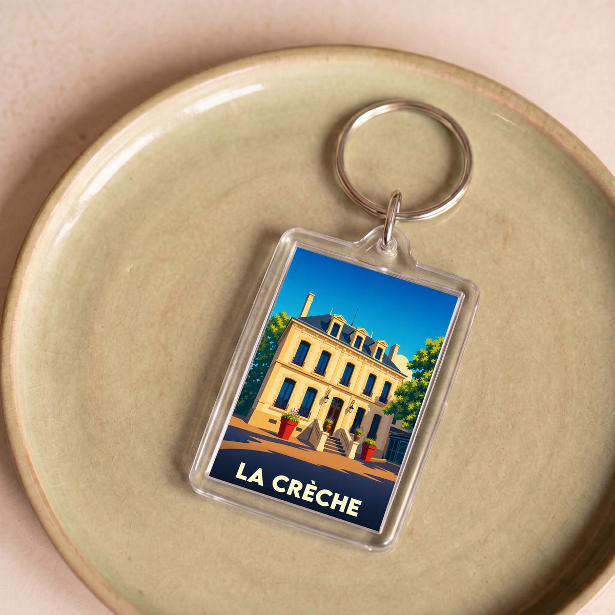 Porte-clés souvenir de la ville de La Crèche avec une illustration stylisée d'un bâtiment historique.