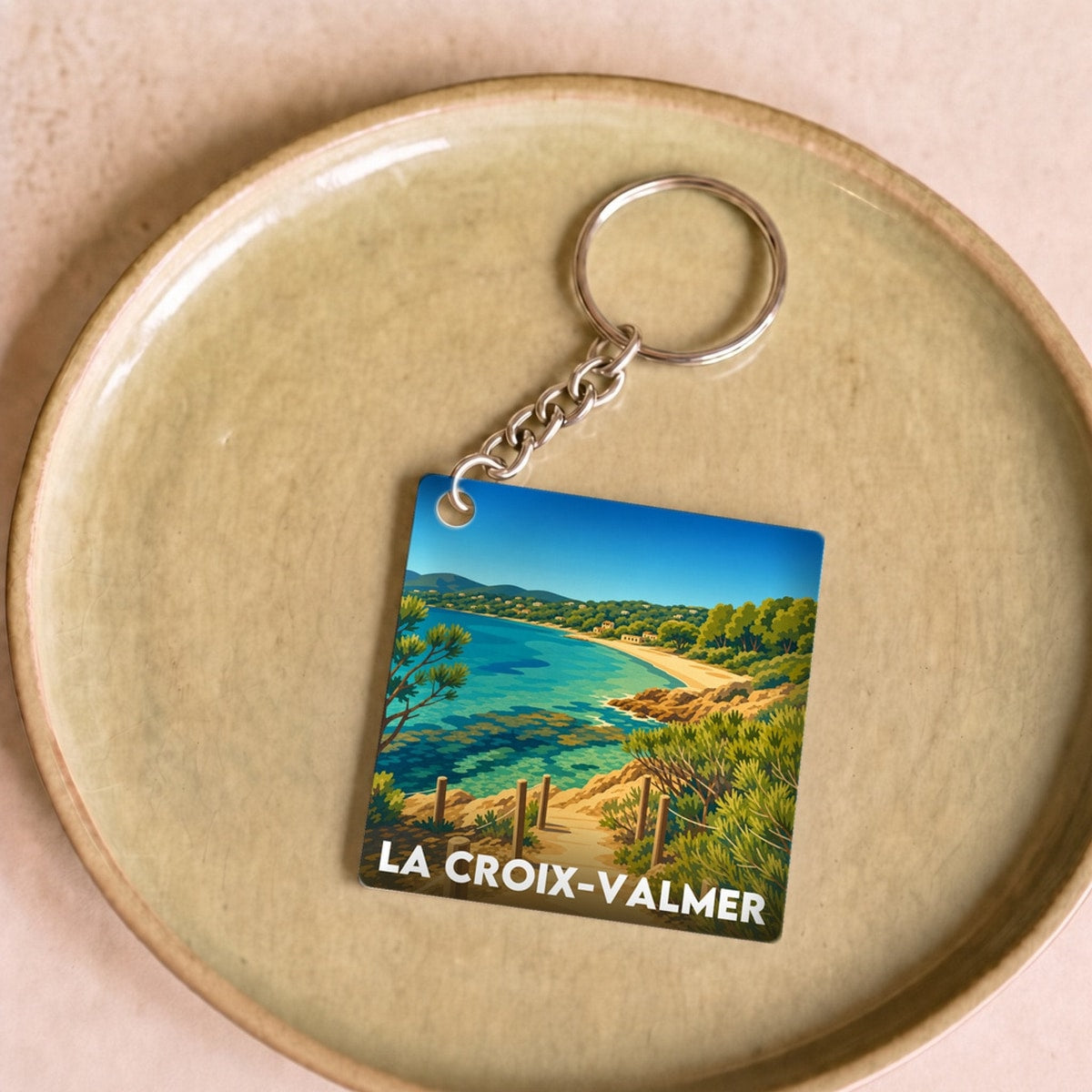 Porte-clés souvenir de la ville de La Croix-Valmer avec une illustration stylisée d'un paysage côtier.