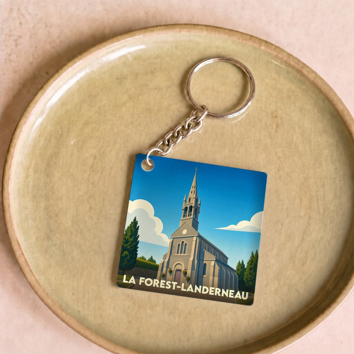 Porte-clés souvenir de la ville de La Forest-Landerneau avec une illustration stylisée de son église.