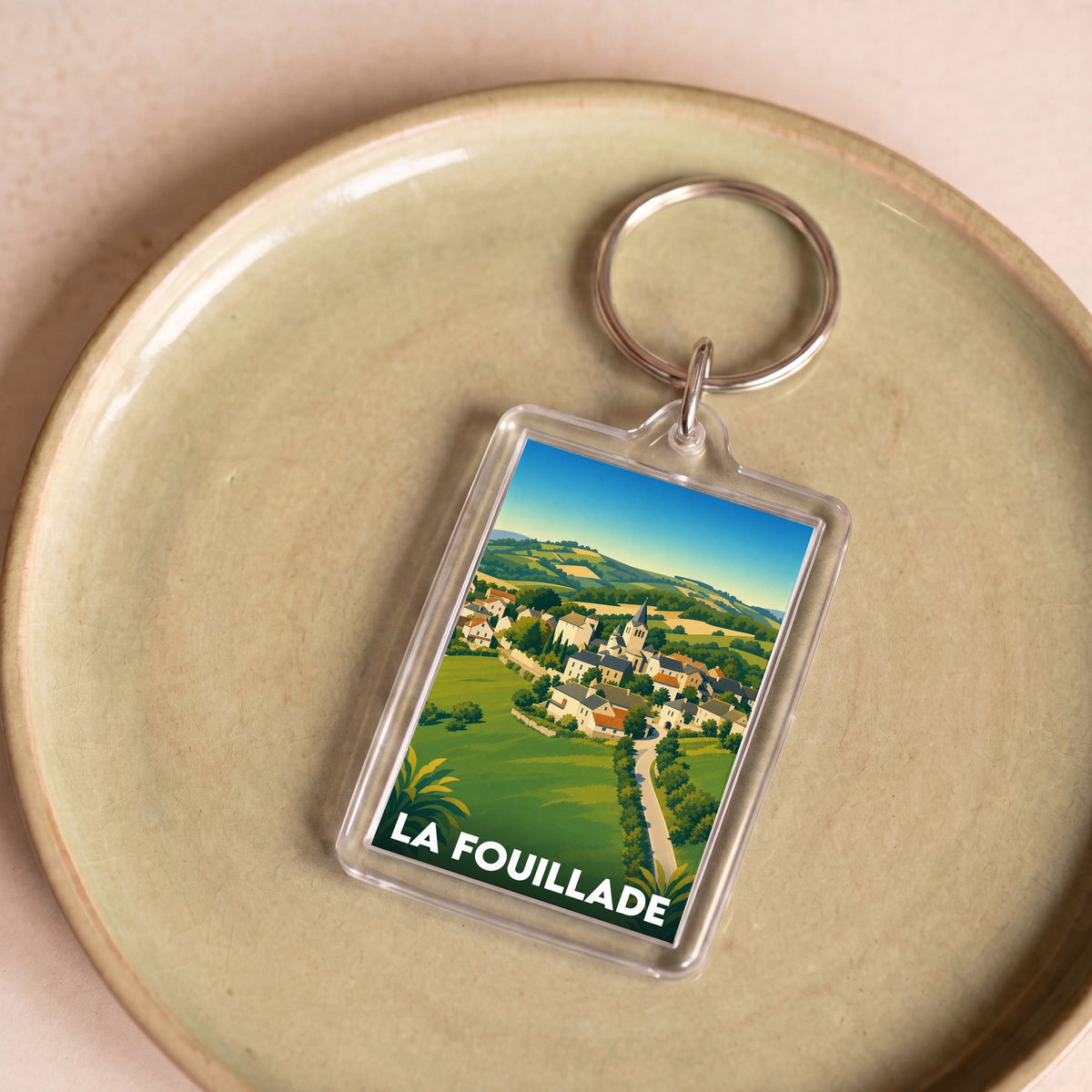 Porte-clés souvenir de la ville de La Fouillade avec une illustration stylisée.