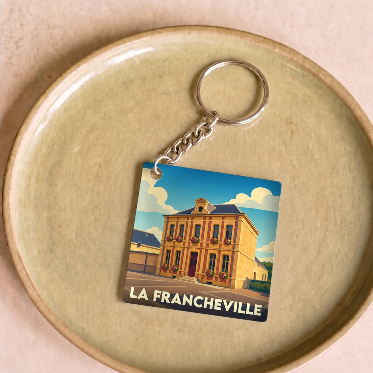 Porte-clés souvenir de la ville de La Francheville avec une illustration stylisée.