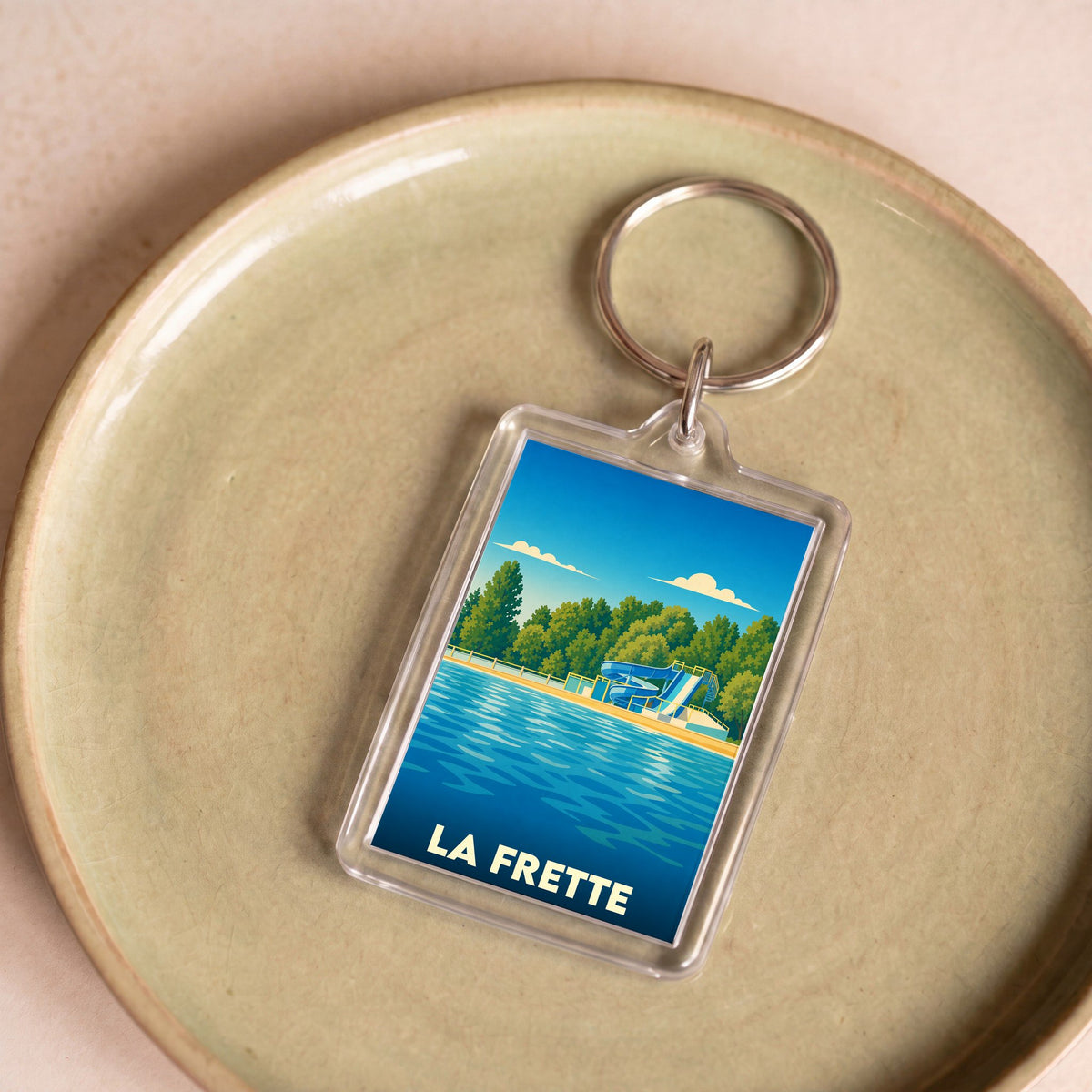Porte-clés souvenir de la ville de La Frette avec une illustration stylisée d'une base de loisirs.