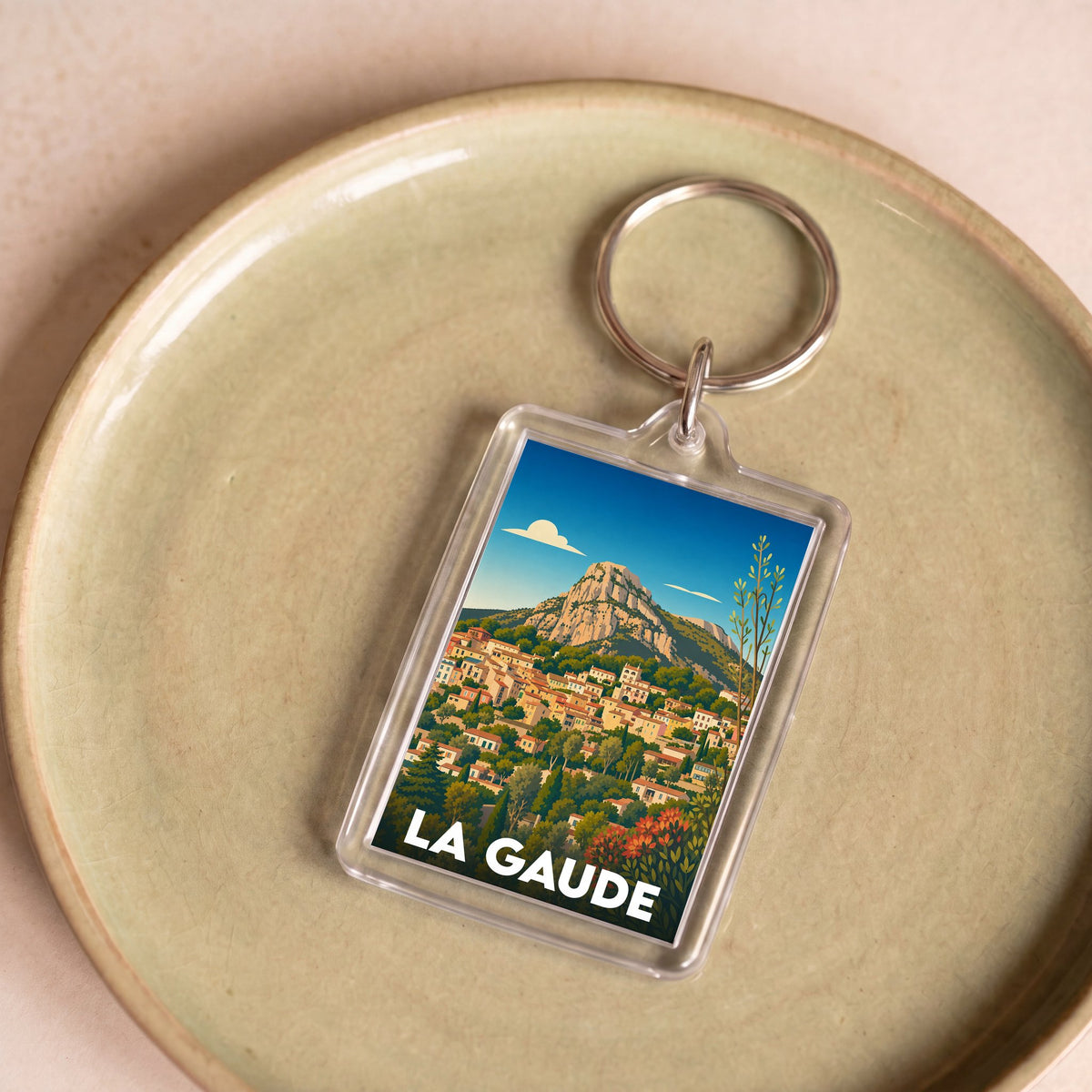 Porte-clés souvenir de la ville de La Gaude avec une illustration colorée et stylisée du village.
