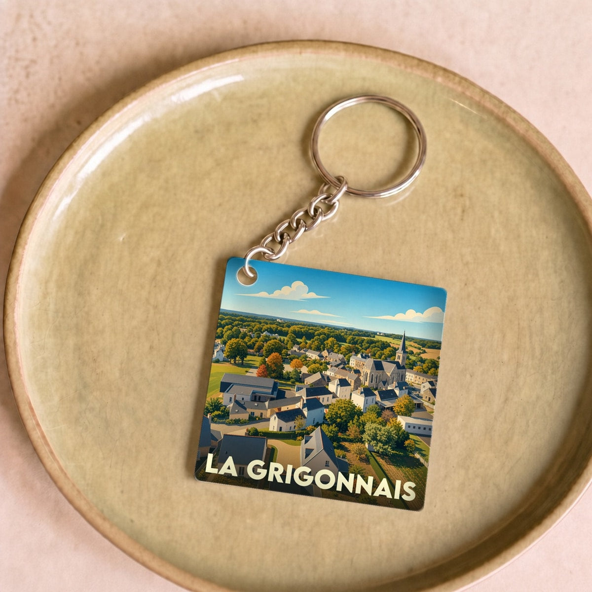 Porte-clés souvenir de la ville de La Grigonnais avec une illustration stylisée.