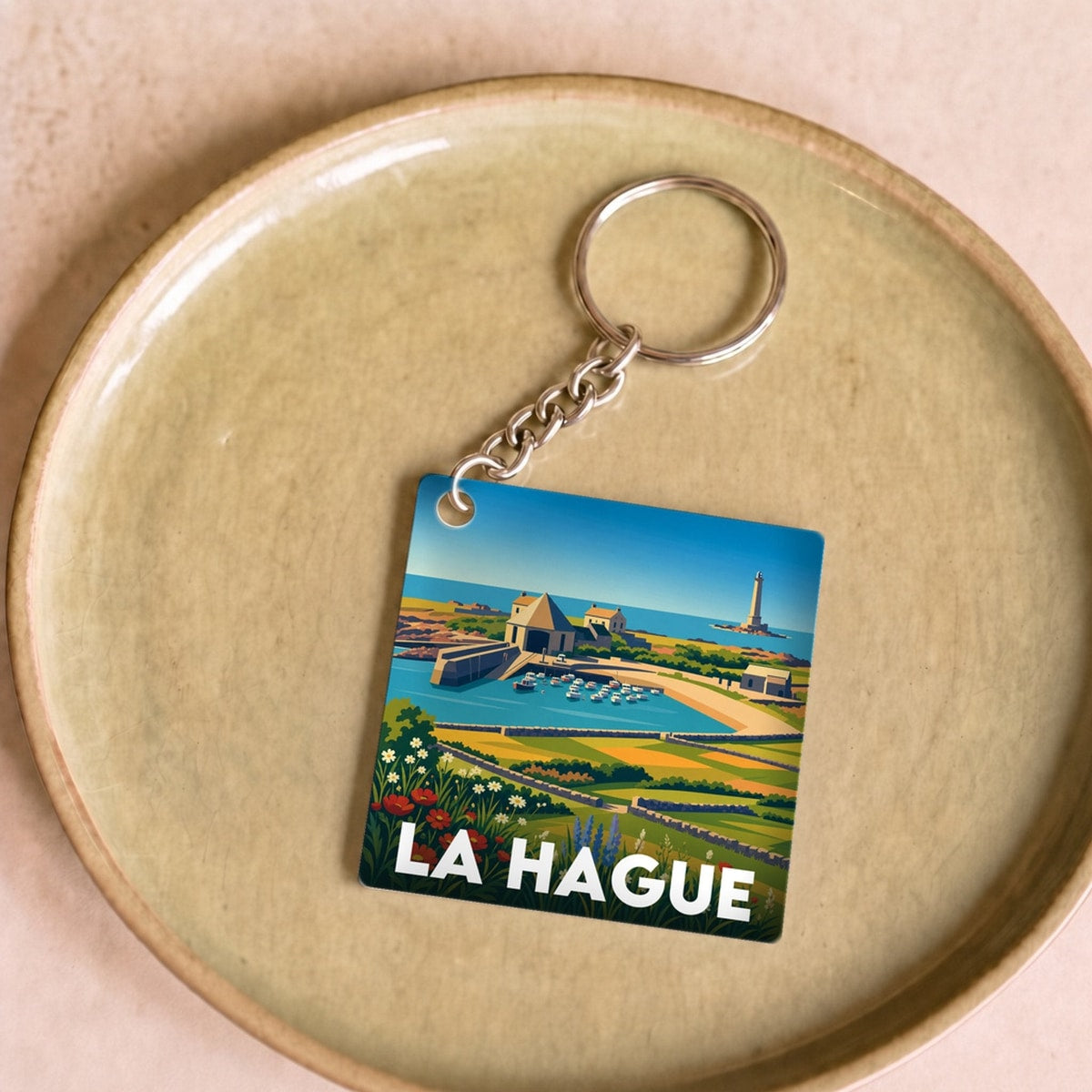 Porte-clés souvenir de la ville de La Hague avec une illustration stylisée.