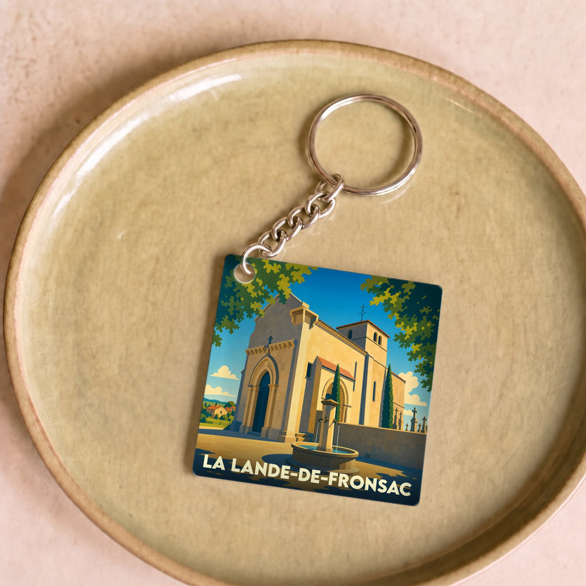 Porte-clés souvenir de la ville de La Lande-de-Fronsac avec une illustration stylisée de son église.
