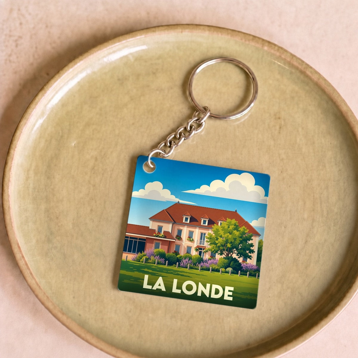 Porte-clés souvenir de la ville de La Londe avec une illustration stylisée.