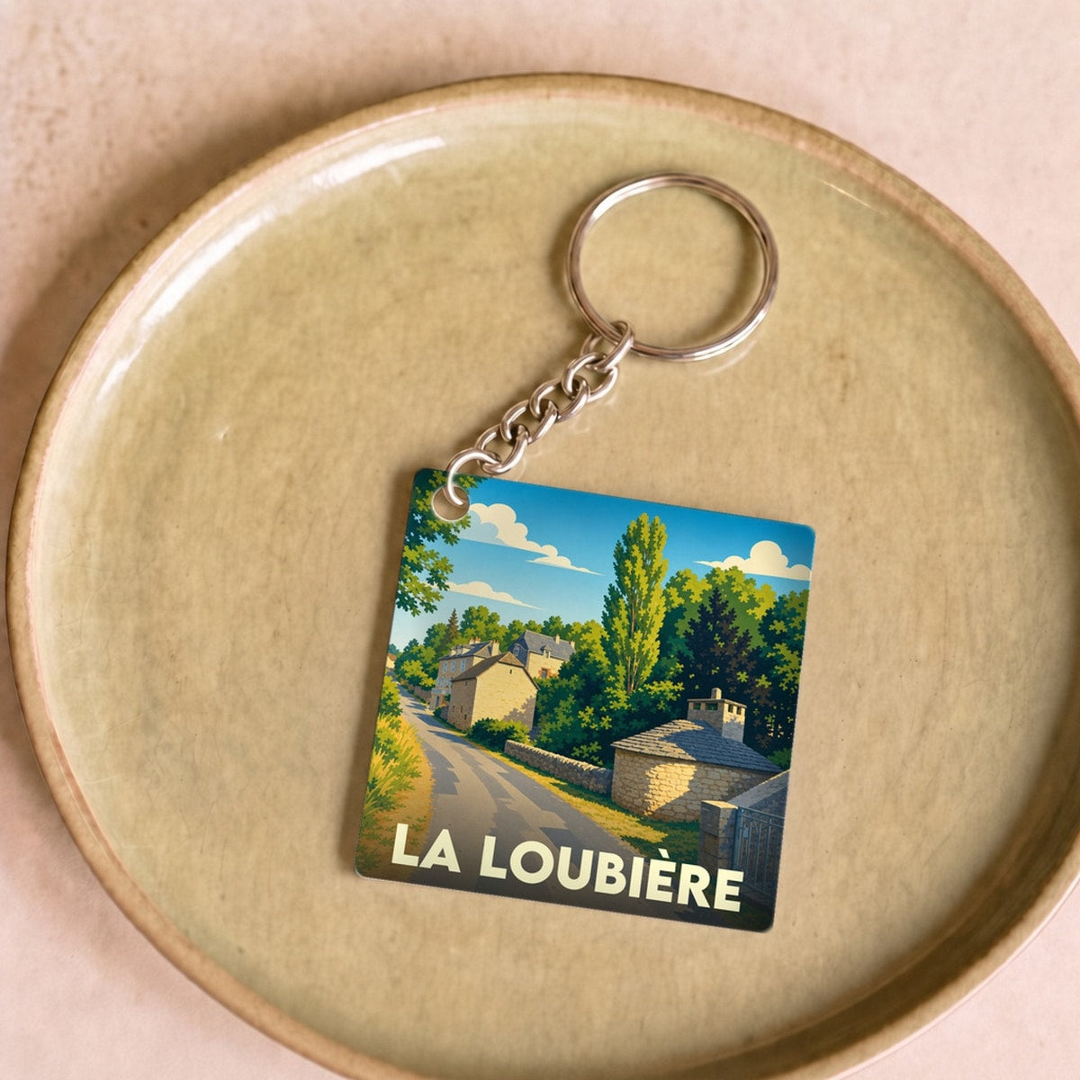 Porte-clés souvenir de la ville de La Loubière avec une illustration stylisée de village.