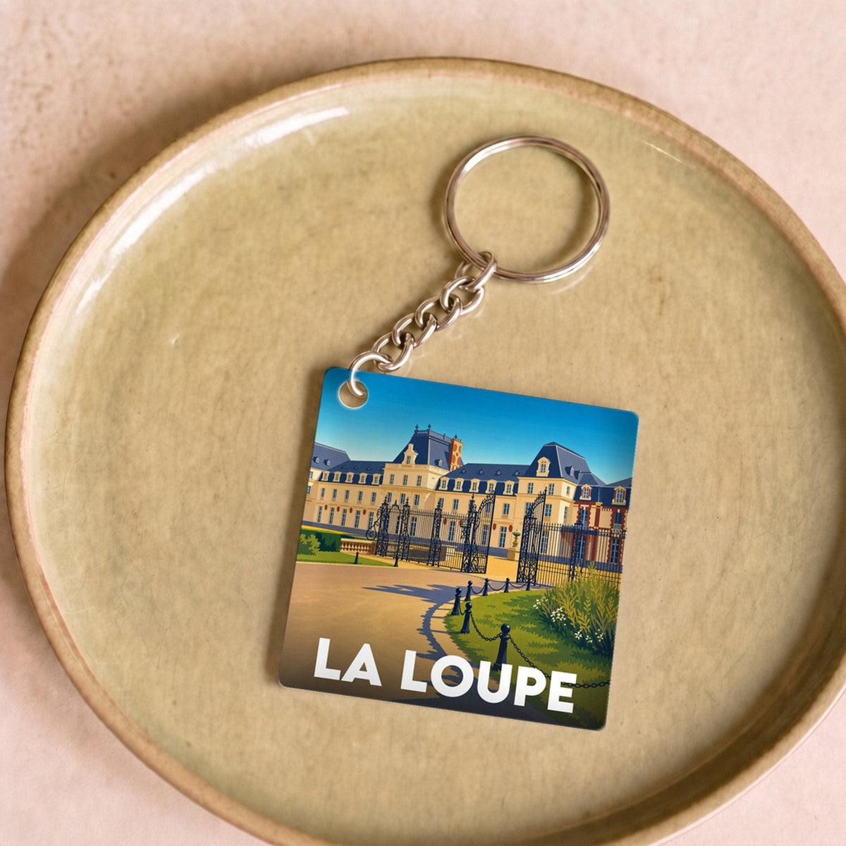 Porte-clés souvenir de la ville de La Loupe avec une illustration stylisée.
