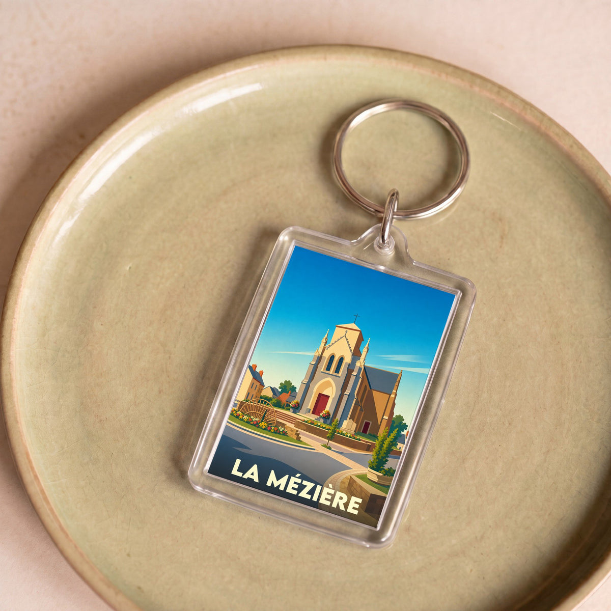 Porte-clés souvenir de la ville de La Mézière avec une illustration stylisée de son église.