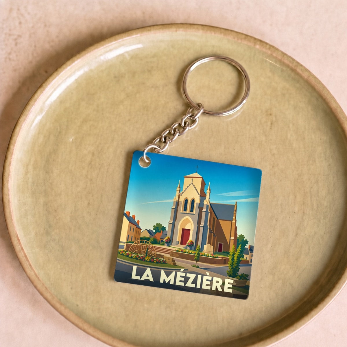 Porte-clés souvenir de la ville de La Mézière avec une illustration stylisée de son église.