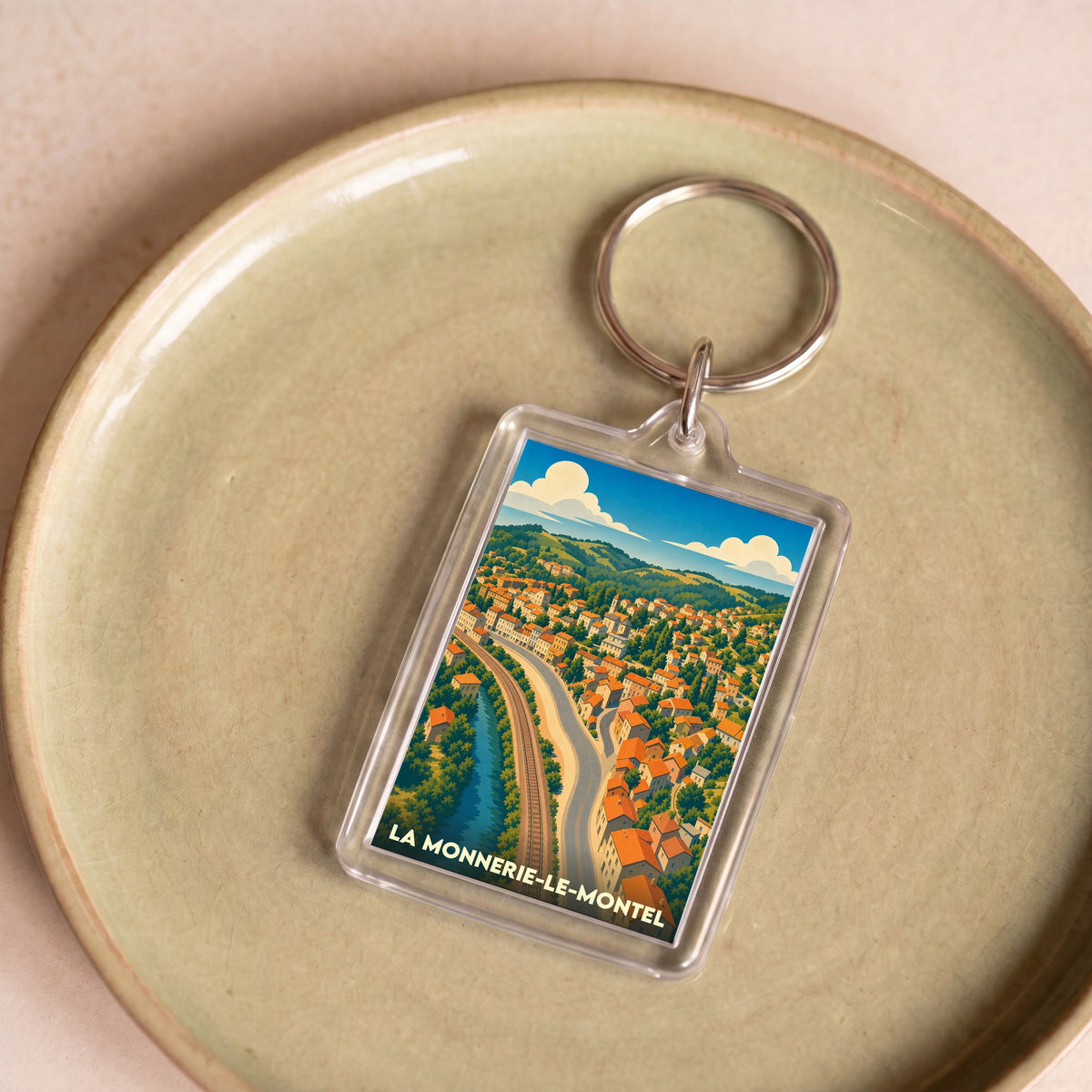 Porte-clés souvenir de la ville de La Monnerie-le-Montel avec une illustration stylisée.