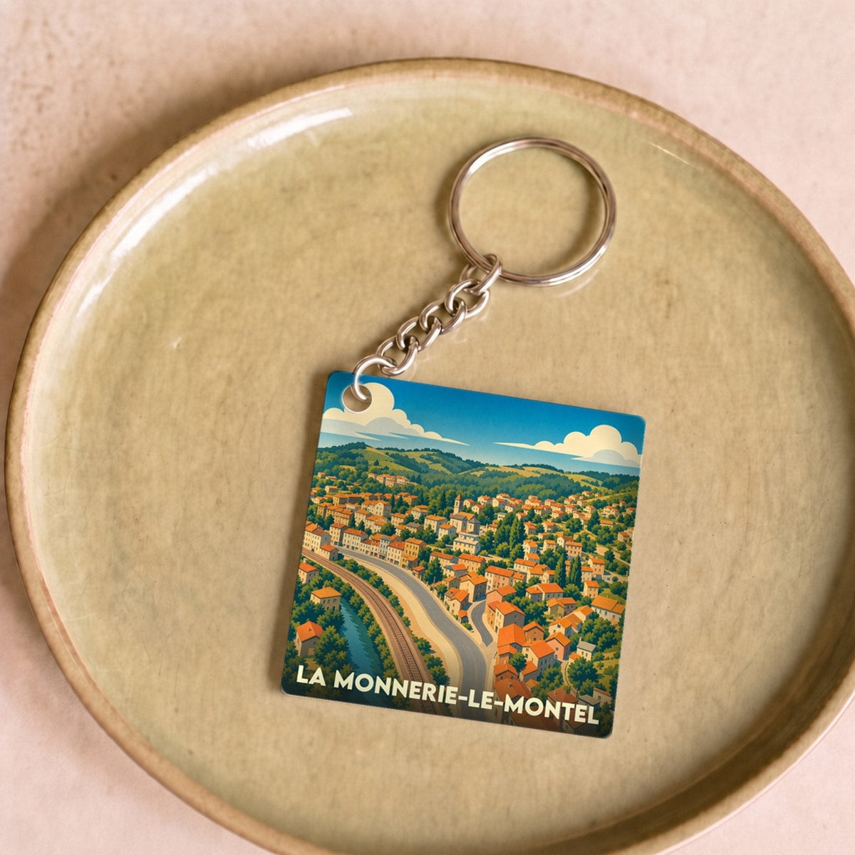 Porte-clés souvenir de la ville de La Monnerie-le-Montel avec une illustration stylisée.