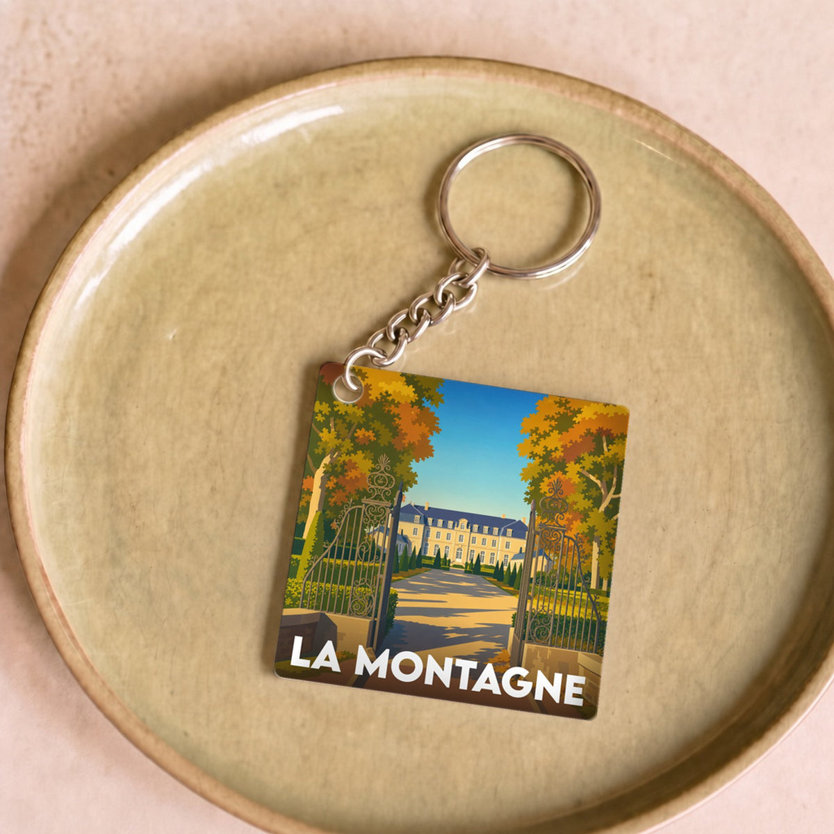 Porte-clés souvenir de la ville de La Montagne avec une illustration stylisée d'un domaine arboré.