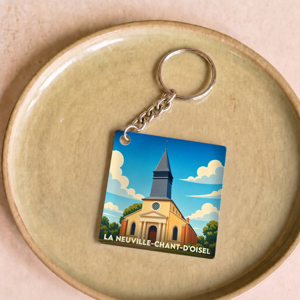 Porte-clés souvenir de la ville de La Neuville-Chant-d'Oisel avec une illustration stylisée de son église.