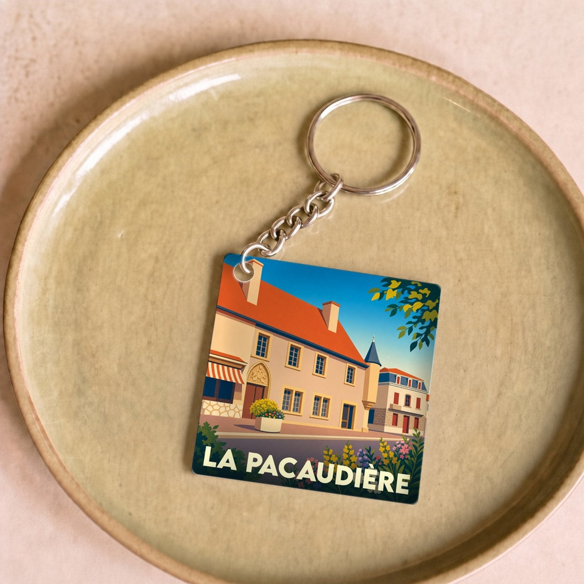 Porte-clés souvenir de la ville de La Pacaudière avec une illustration stylisée.