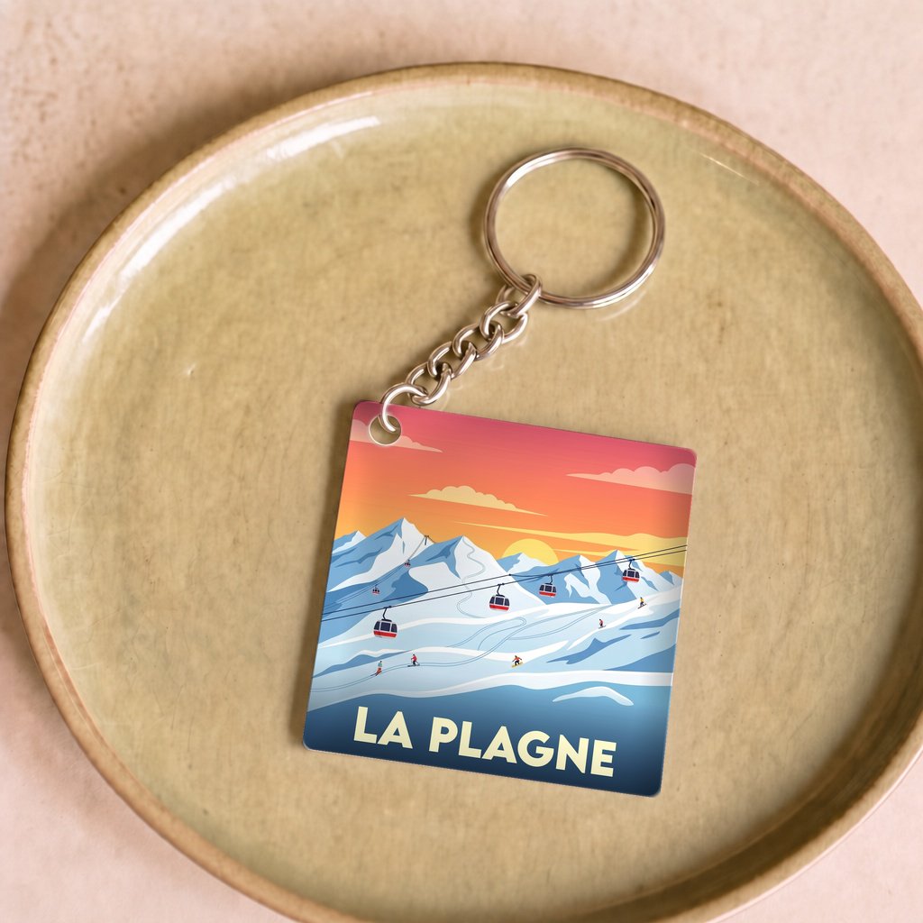 Porte-clés souvenir de la ville de La Plagne avec une illustration stylisée.