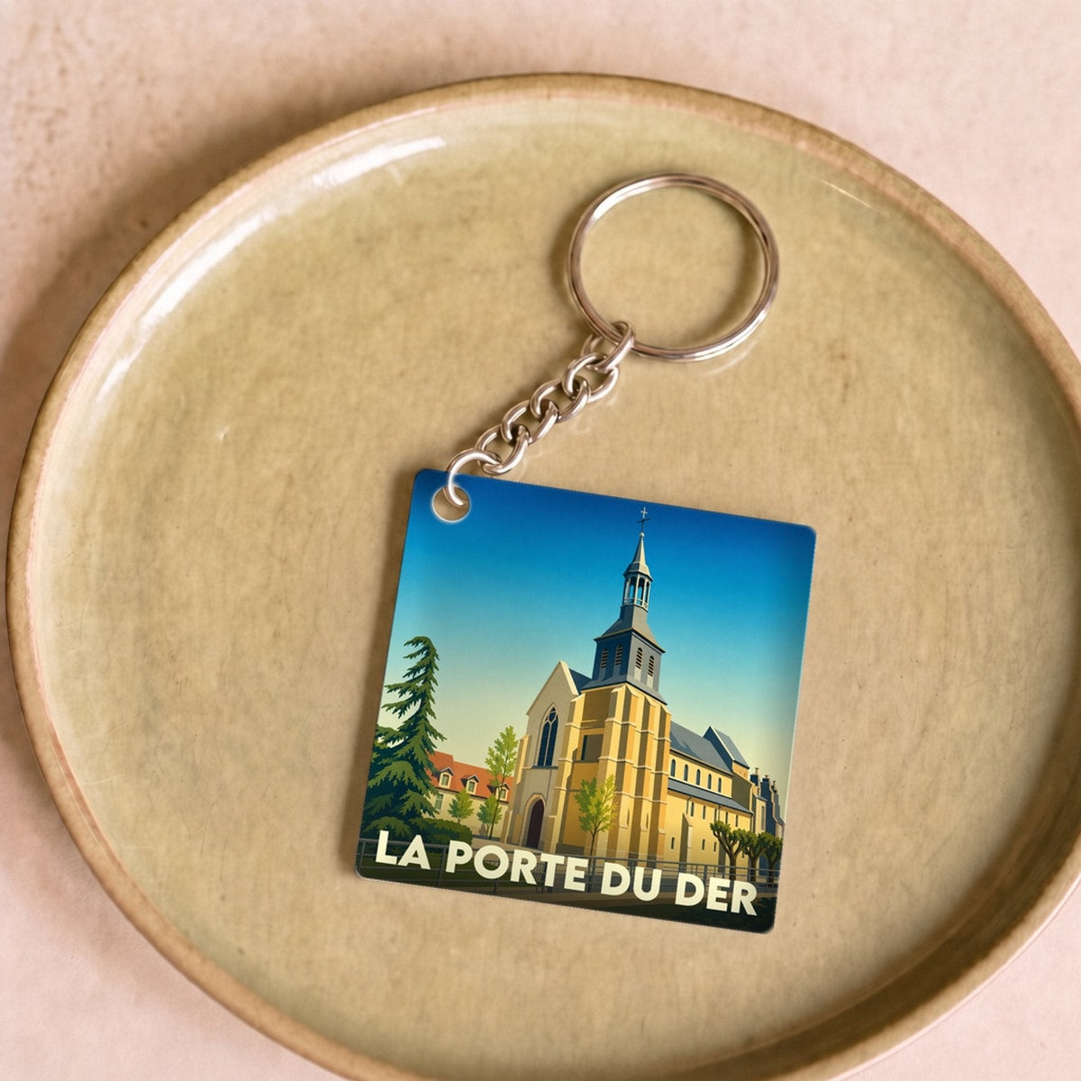 Porte-clés souvenir de la ville de La Porte du Der avec une illustration stylisée d'une église.