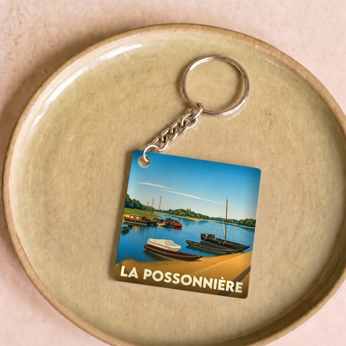 Porte-clés souvenir de la ville de La Possonnière avec une illustration stylisée de bateaux sur la Loire.