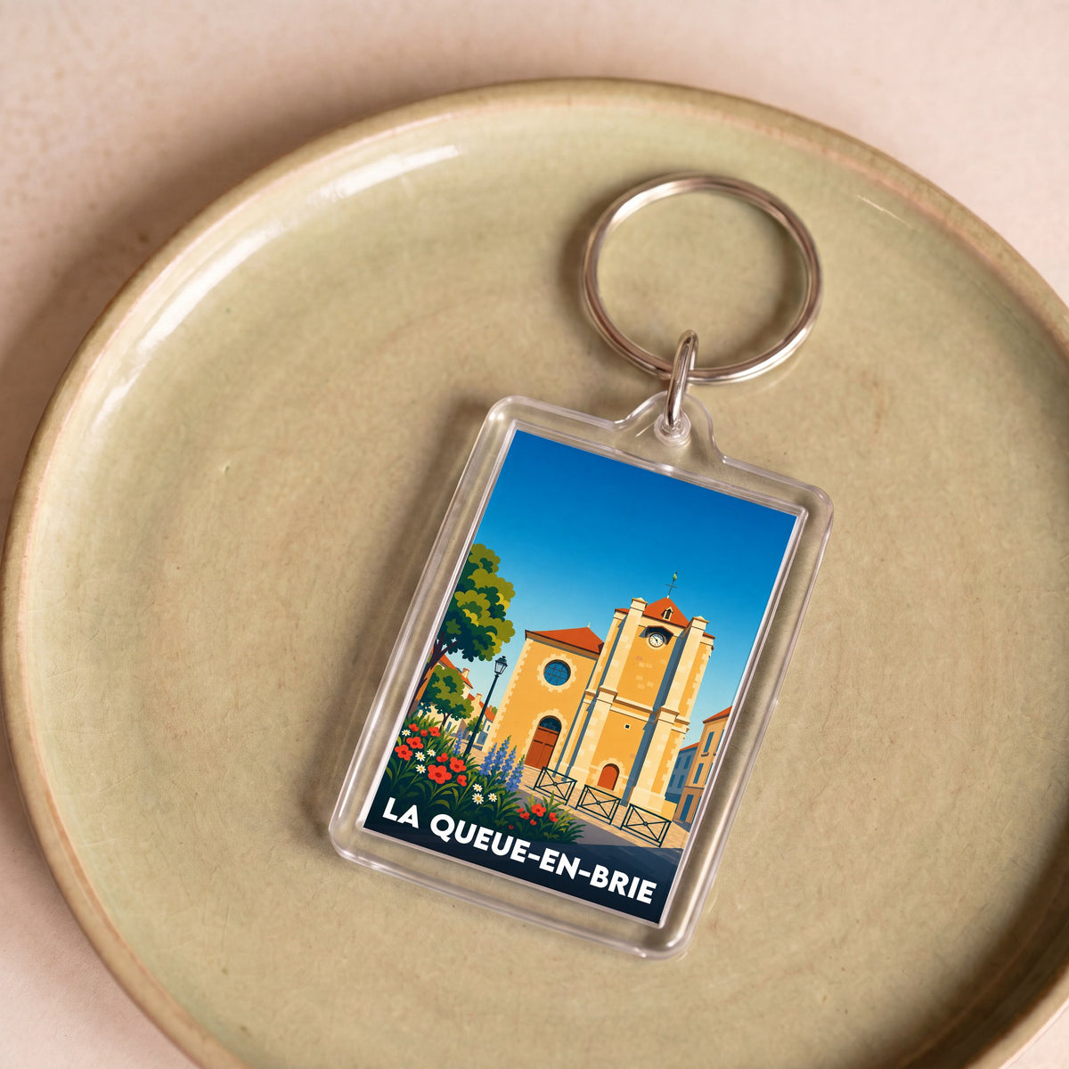 Porte-clés souvenir de la ville de La Queue-en-Brie avec une illustration stylisée.