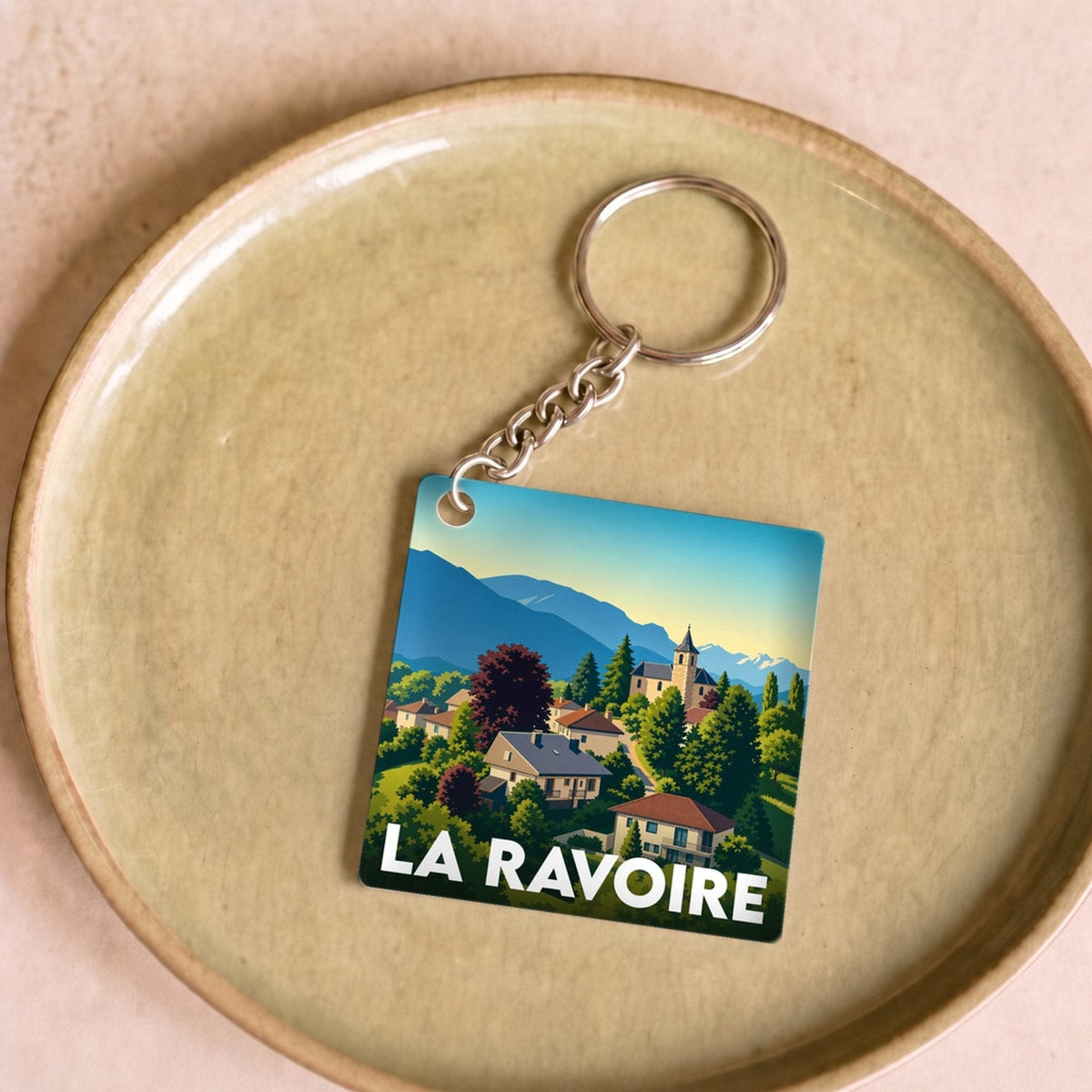 Porte-clés souvenir de la ville de La Ravoire avec une illustration stylisée de son paysage.