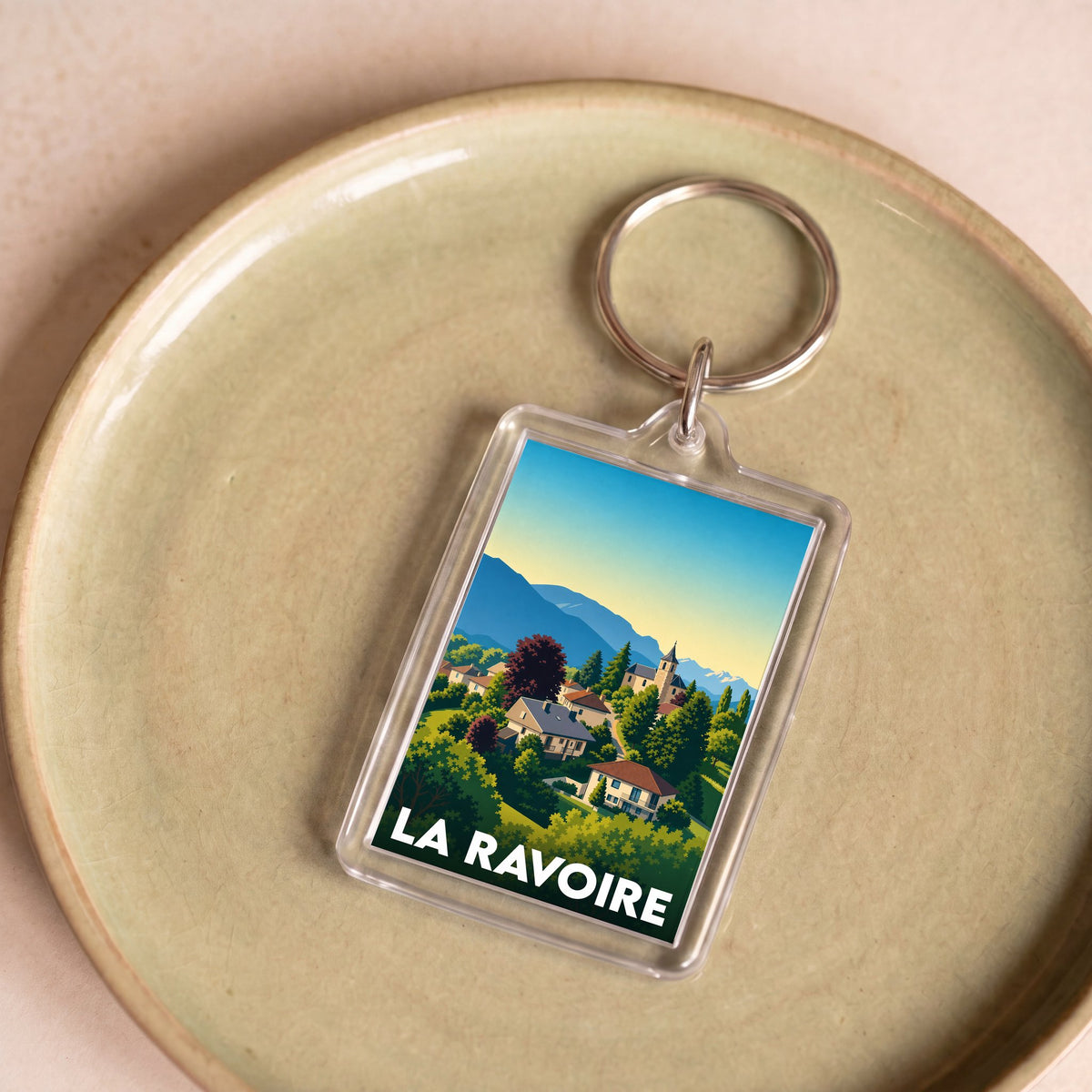 Porte-clés souvenir de la ville de La Ravoire avec une illustration stylisée de son paysage.
