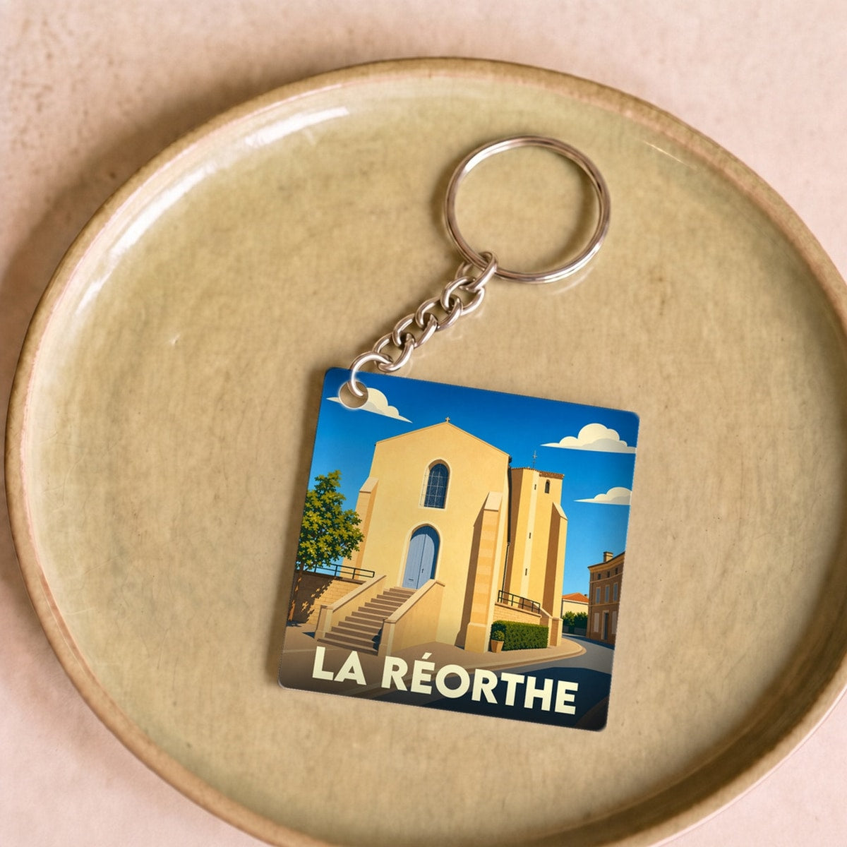 Porte-clés souvenir de la ville de La Réorthe avec une illustration stylisée de son église.