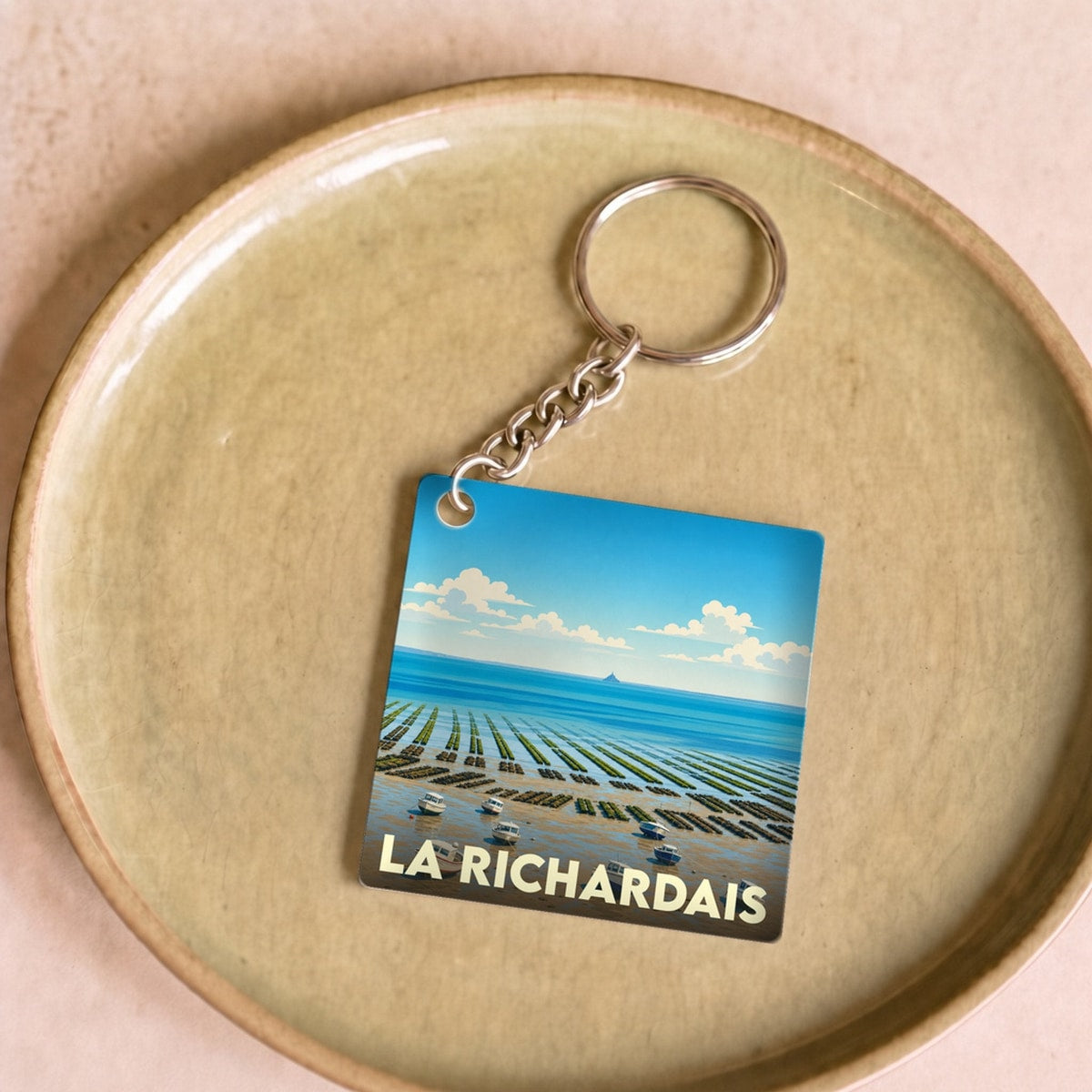 Porte-clés souvenir de la ville de La Richardais avec une illustration stylisée de son paysage côtier.