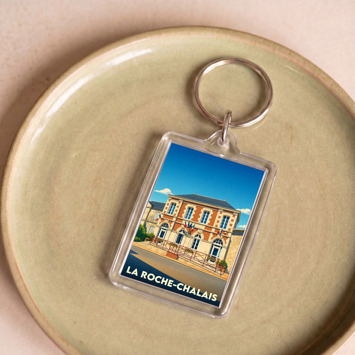 Porte-clés souvenir de la ville de La Roche-Chalais avec une illustration stylisée de sa mairie.