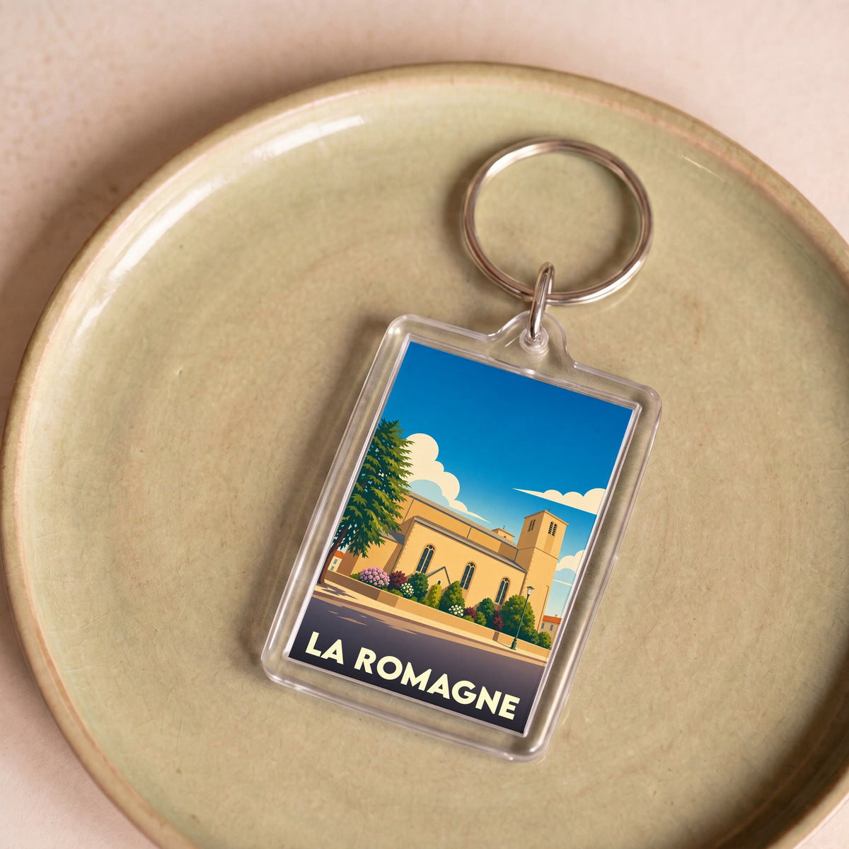 Porte-clés souvenir de la ville de La Romagne avec une illustration stylisée.