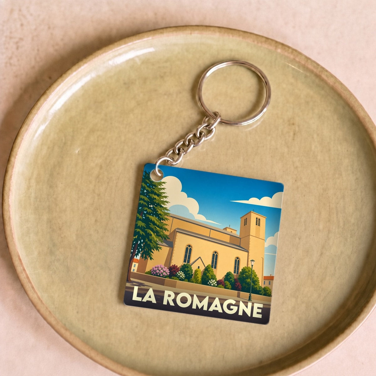 Porte-clés souvenir de la ville de La Romagne avec une illustration stylisée.