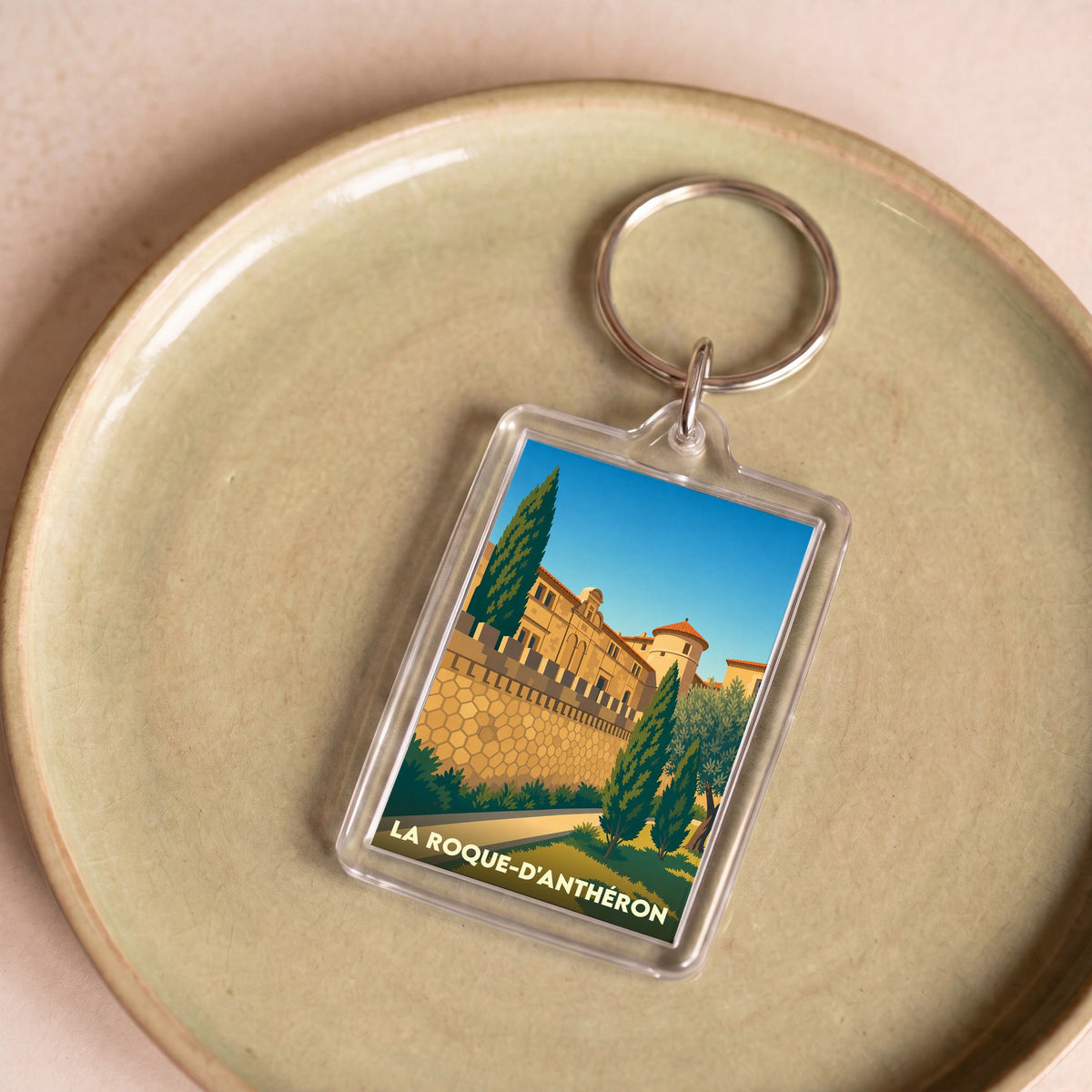 Porte-clés souvenir de la ville de La Roque-d'Anthéron avec une illustration stylisée.